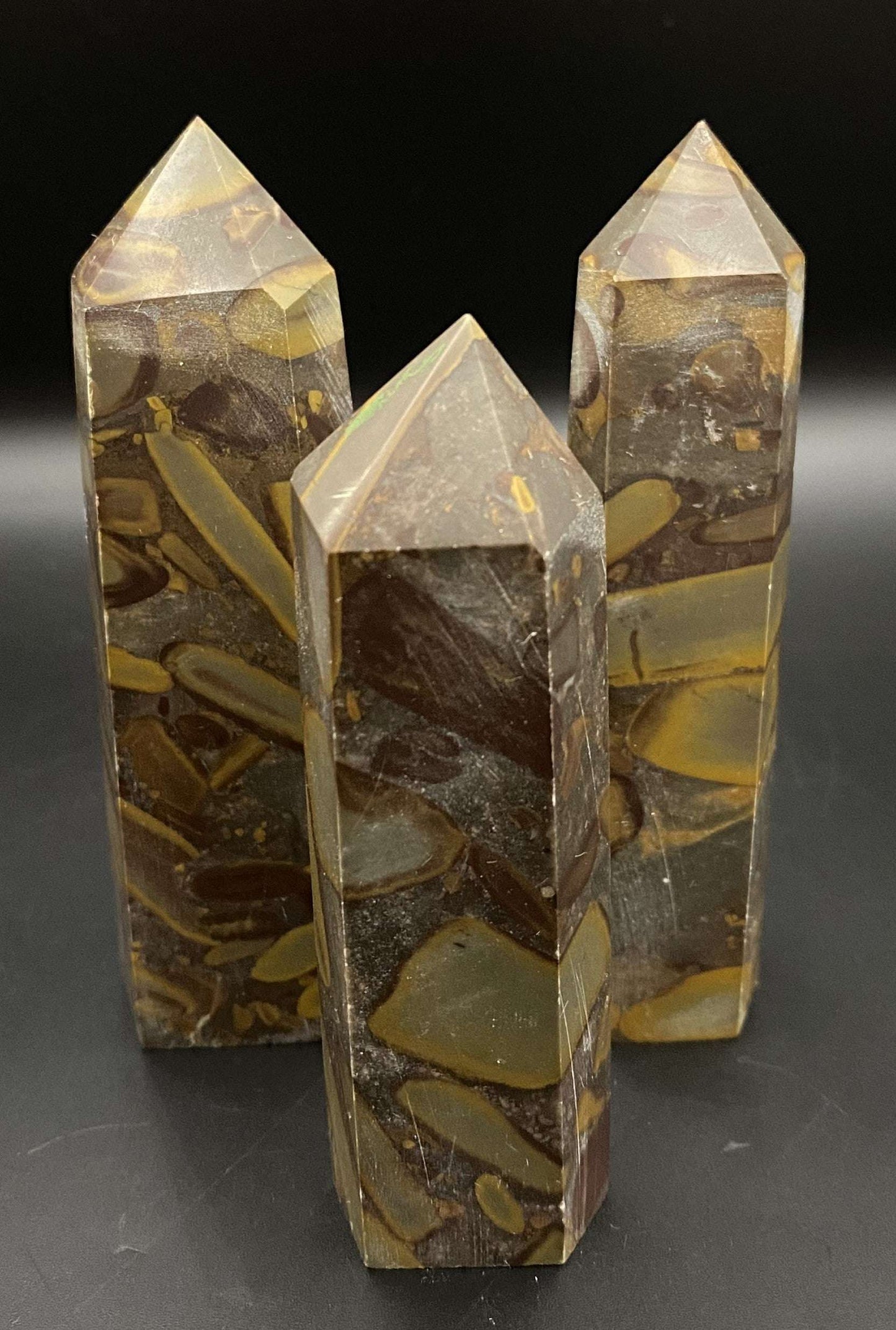 Set of three Jasp Bambus obelisks made from semi-precious stones on black background