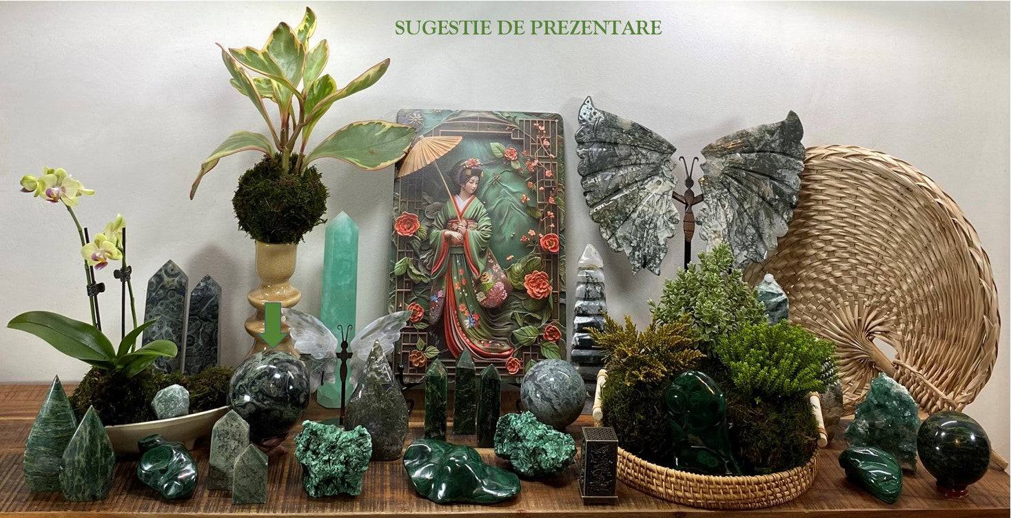 Jasp Kambaba sphere with wooden stand among decorative green gemstones and plants display
