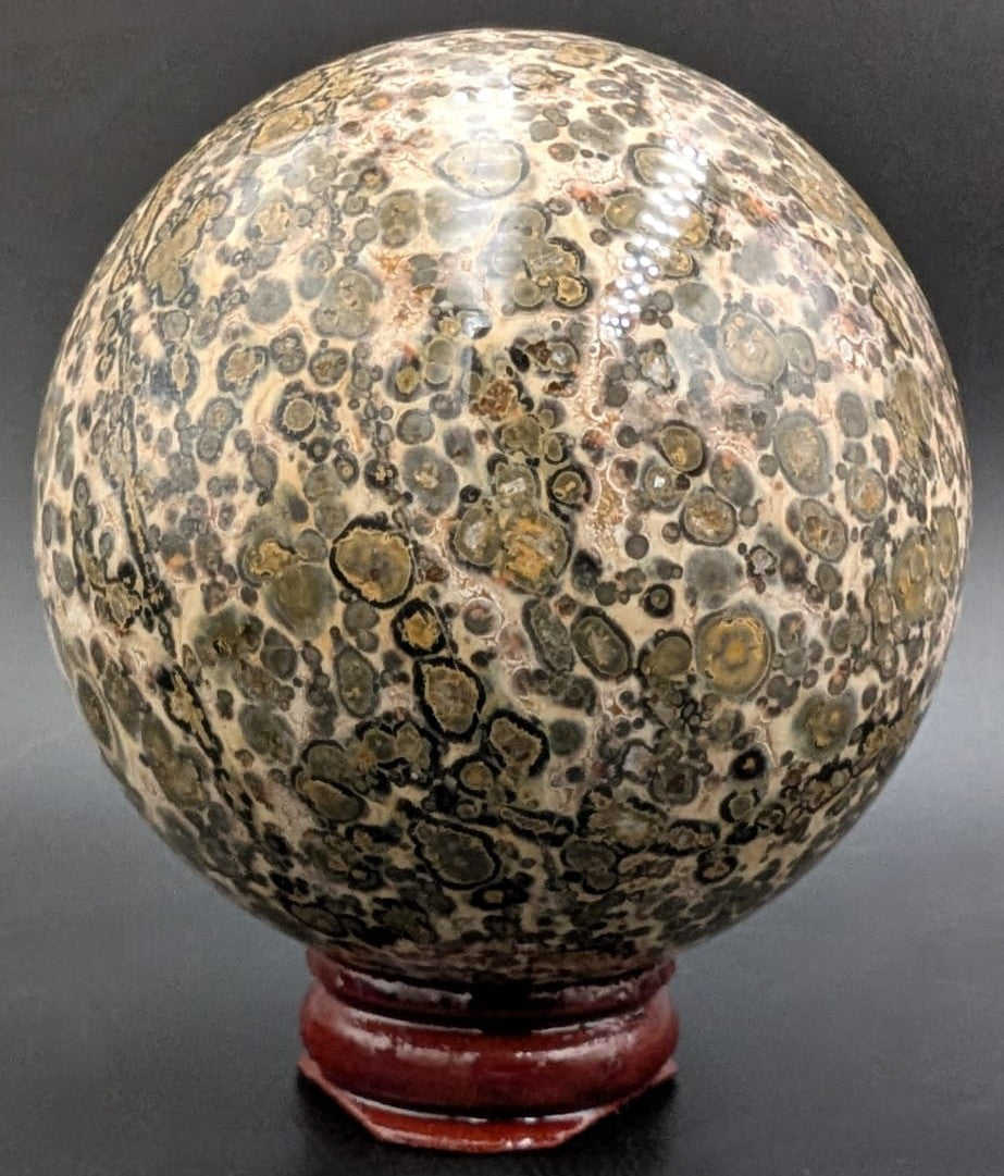 Sfera din piatra semipretioasa de jasp leopard pe suport din lemn cu fundal negru