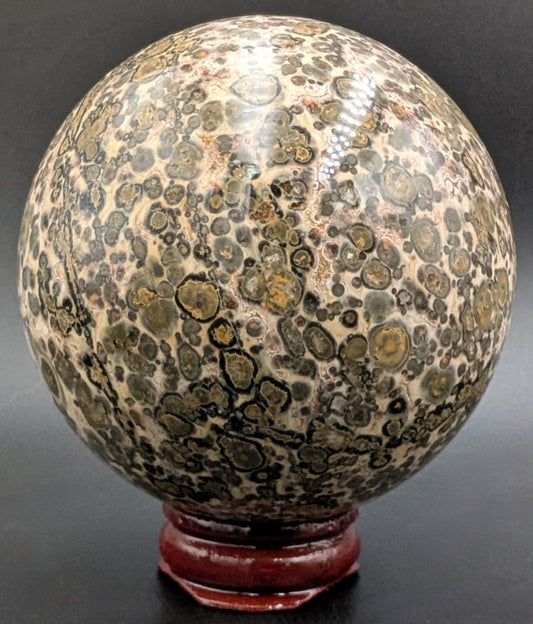 Sfera din piatra semipretioasa de jasp leopard pe suport din lemn cu fundal negru