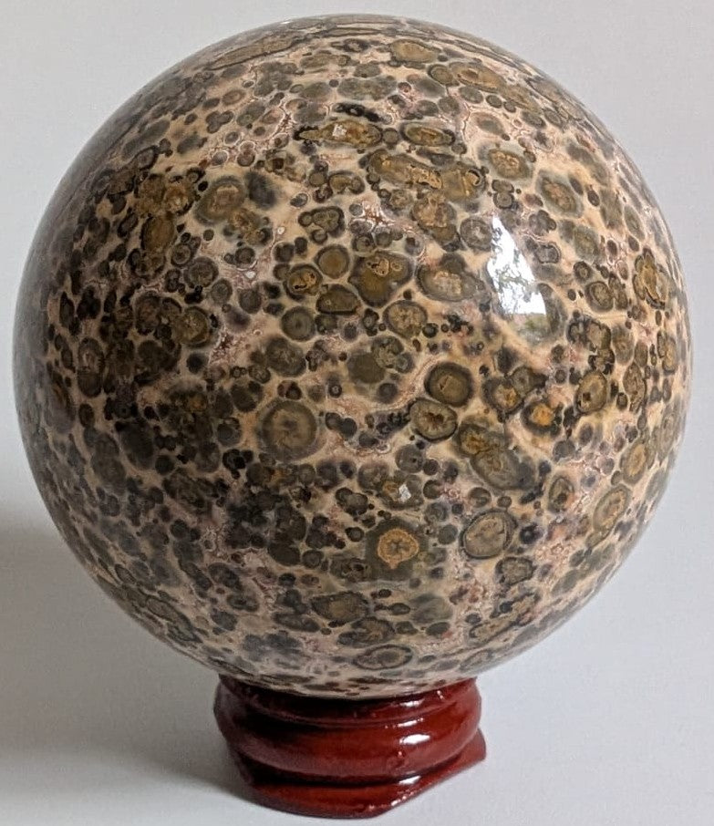 Sfera din piatra semipretioasa de jasp leopard pe suport din lemn cu fundal alb