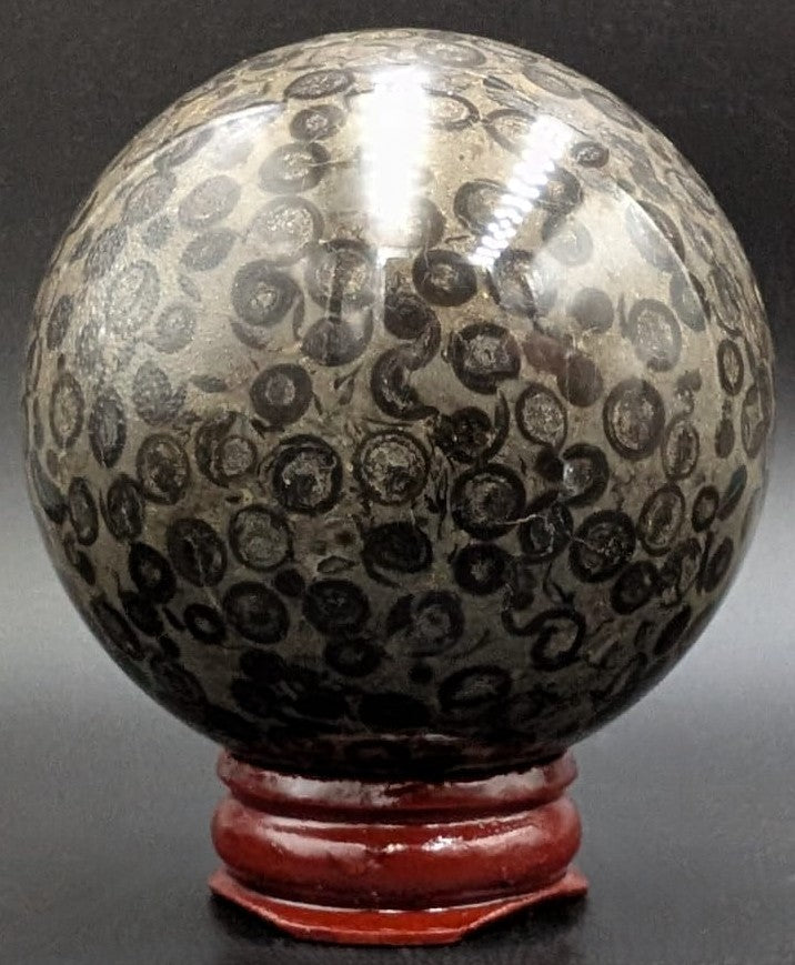 Sfera din piatra semipretioasa de jasp leopard pe suport din lemn cu fundal negru