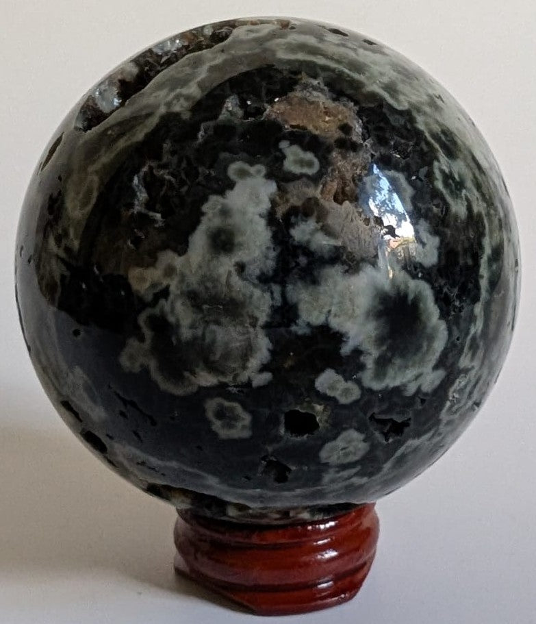 Sfera din cristal de jasp oceanic verde pe suport din lemn cu fundal alb