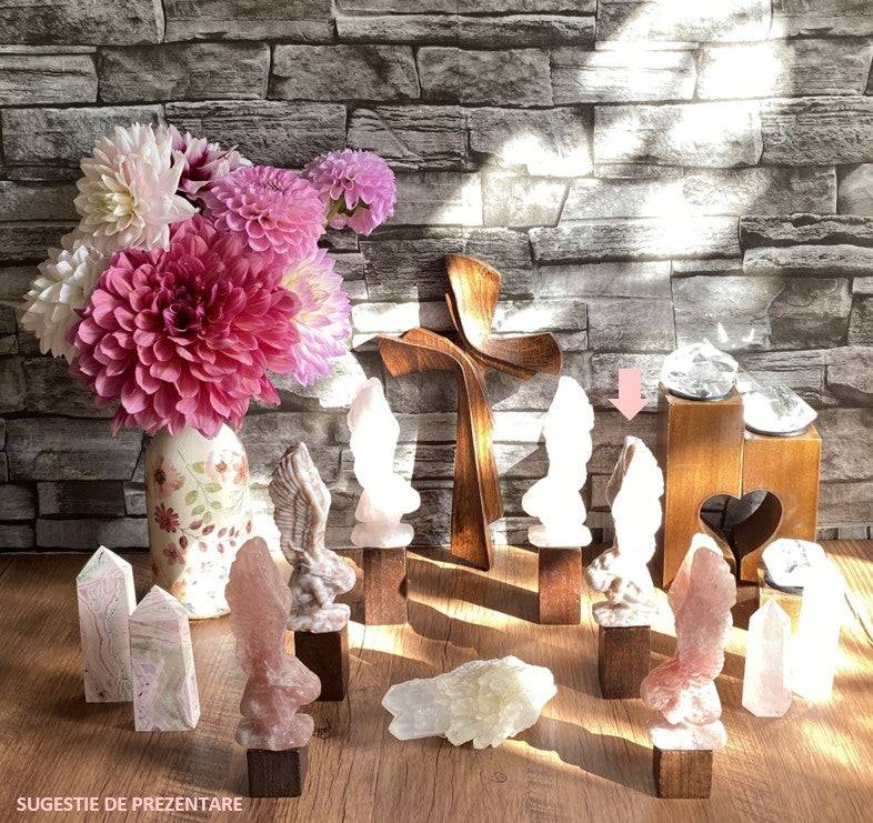 Jasp Red Vein angel figurine in gemstone display with flowers and wooden cross background