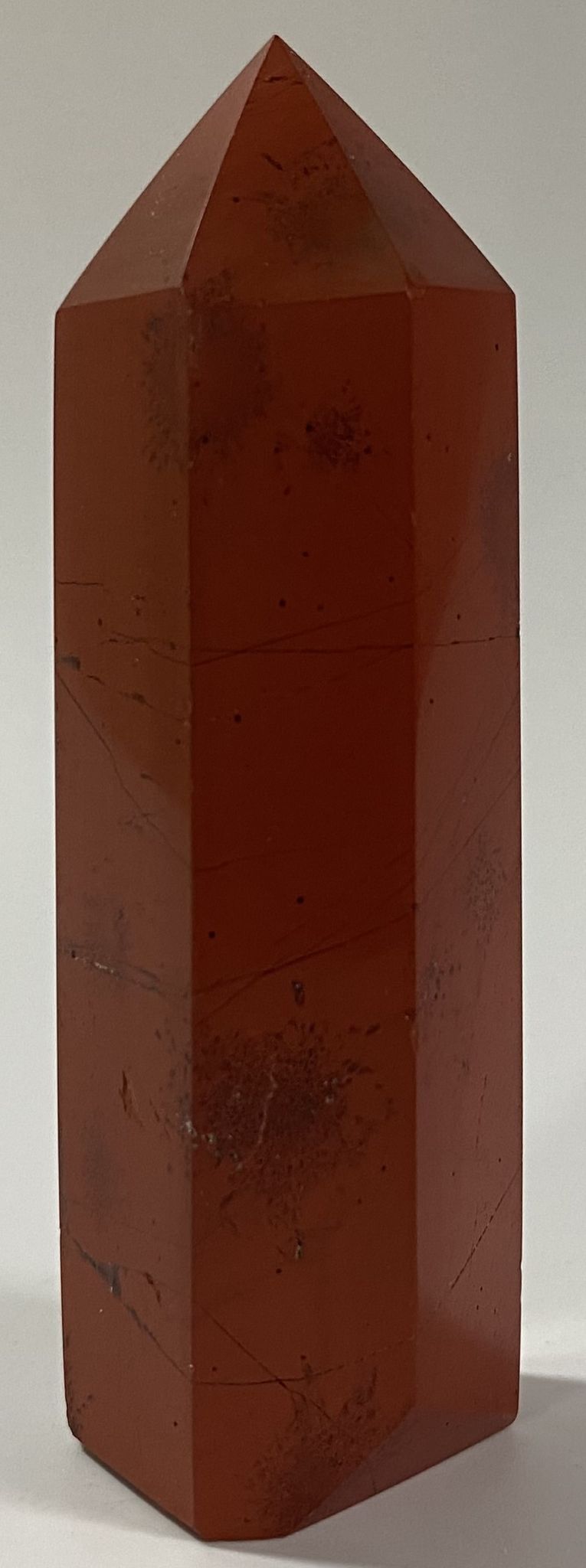Obelisc din cristal de jasp rosu pe fundal alb