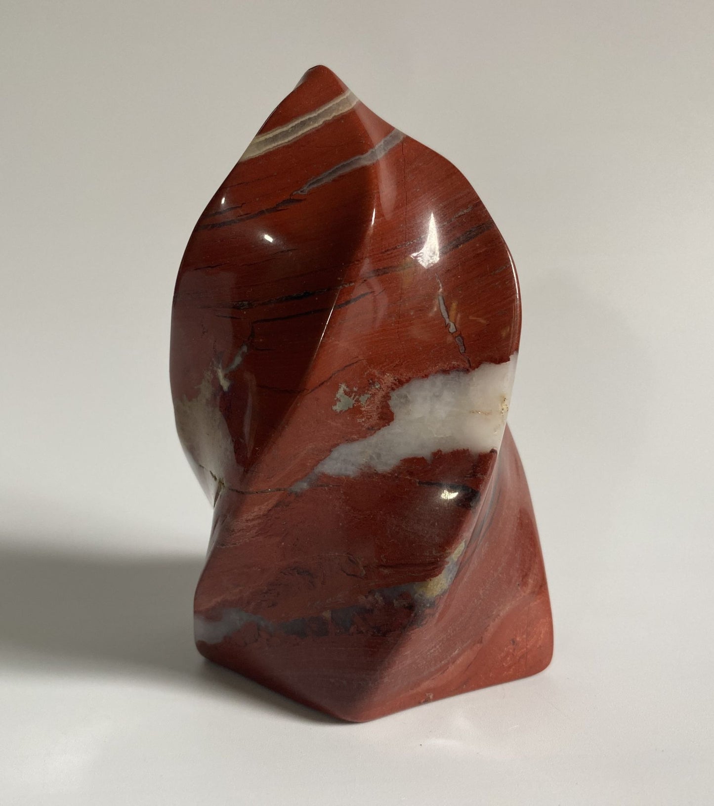 Sculptura din cristal de jasp rosu pe fundal alb