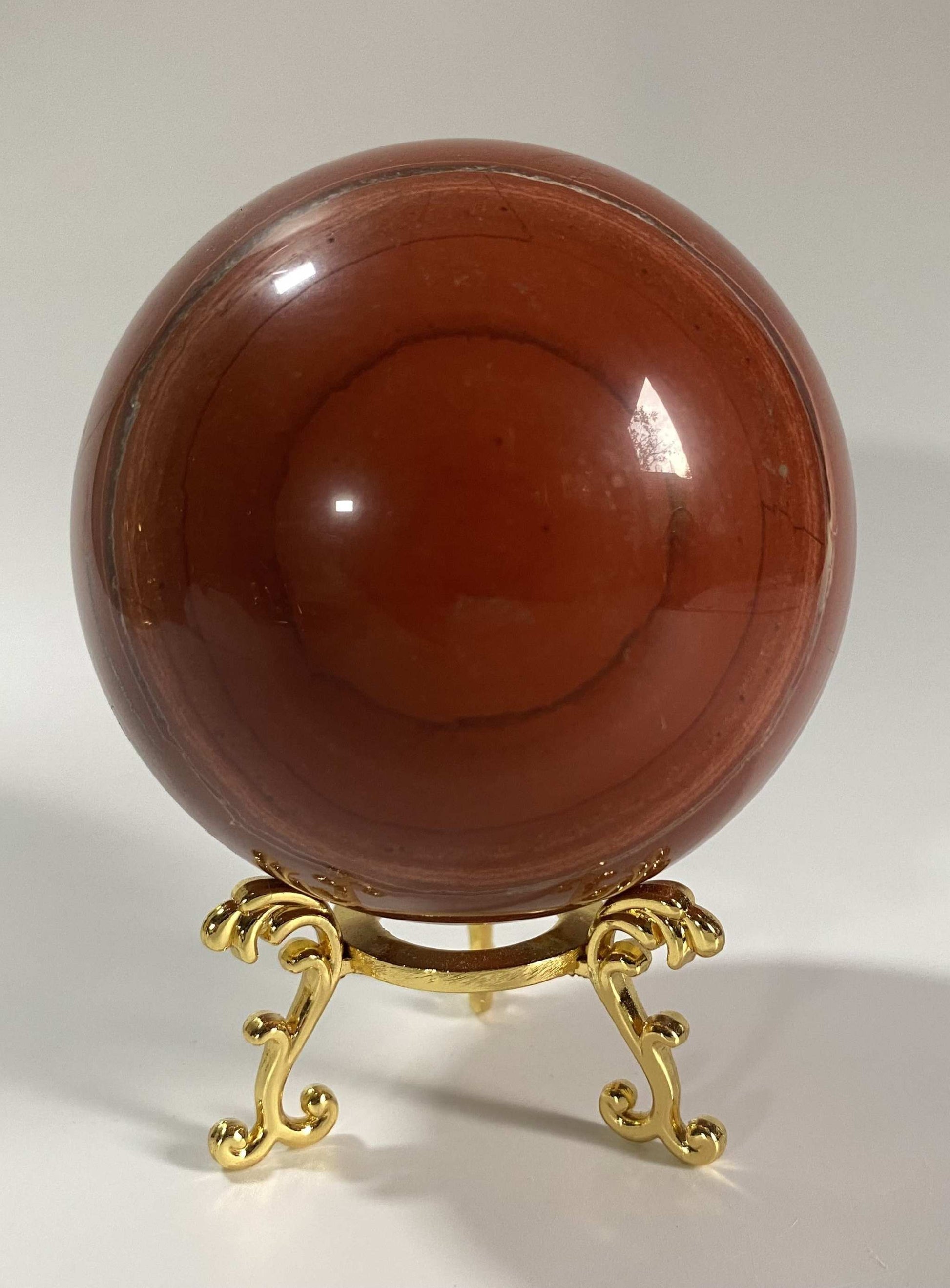 Red Jasper sphere on decorative gold metal stand Jasp Rosu semiprecious stone display