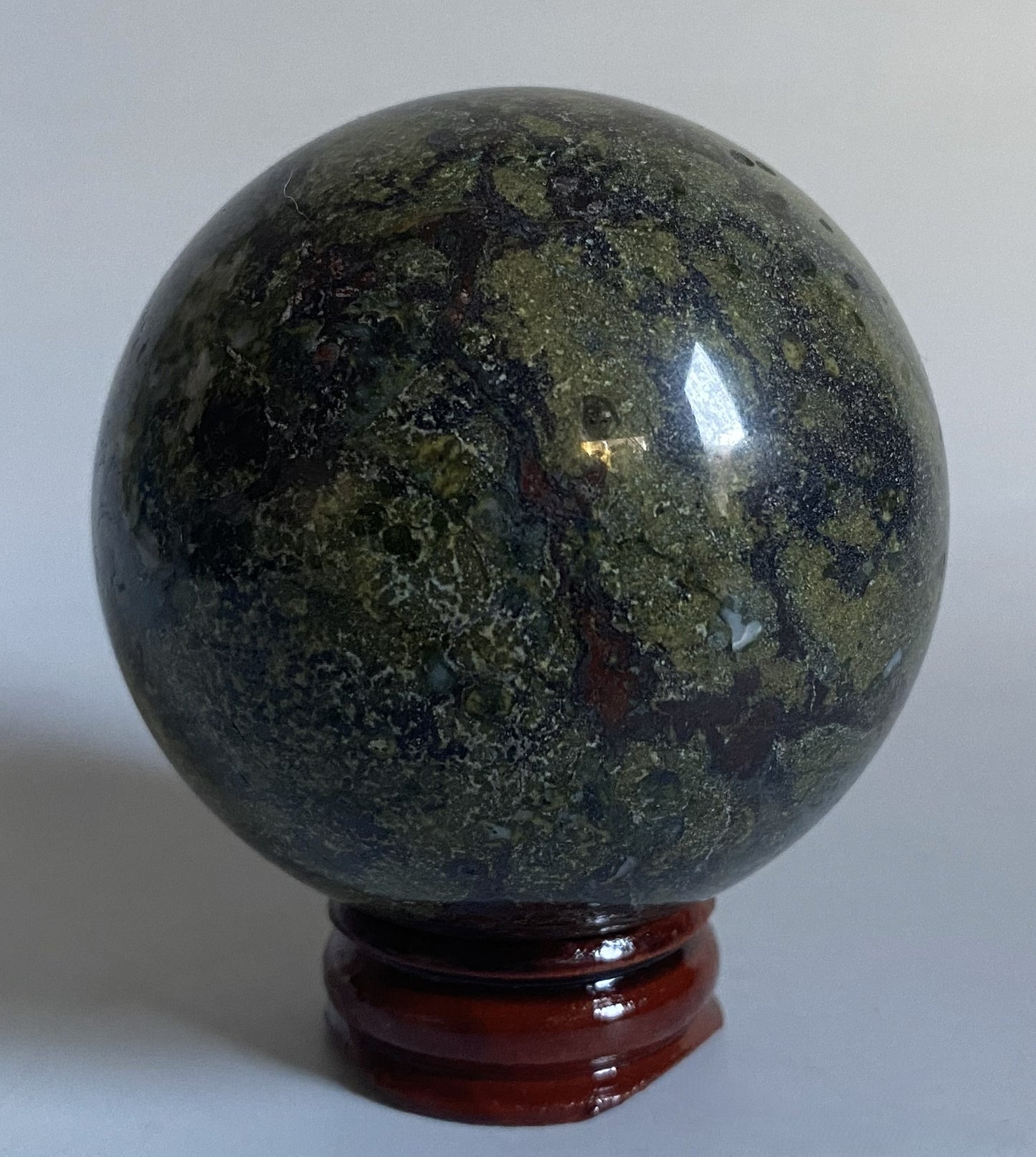 Sfera din cristal de jasp sangele dragonului pe fundal alb