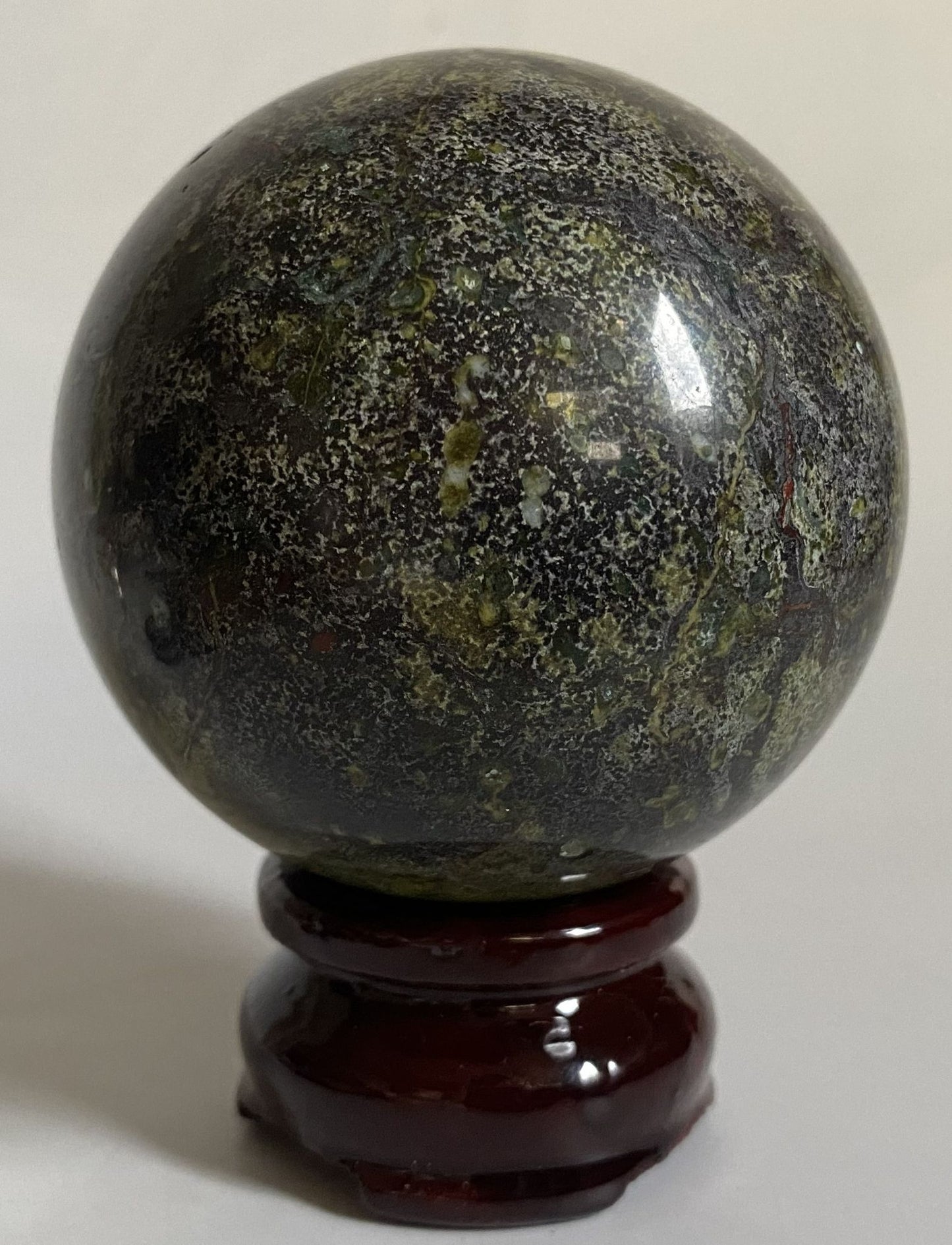 Sfera de 6.8cm din cristal de jasp sangele dragonului pe suport din lemn cu fundal alb