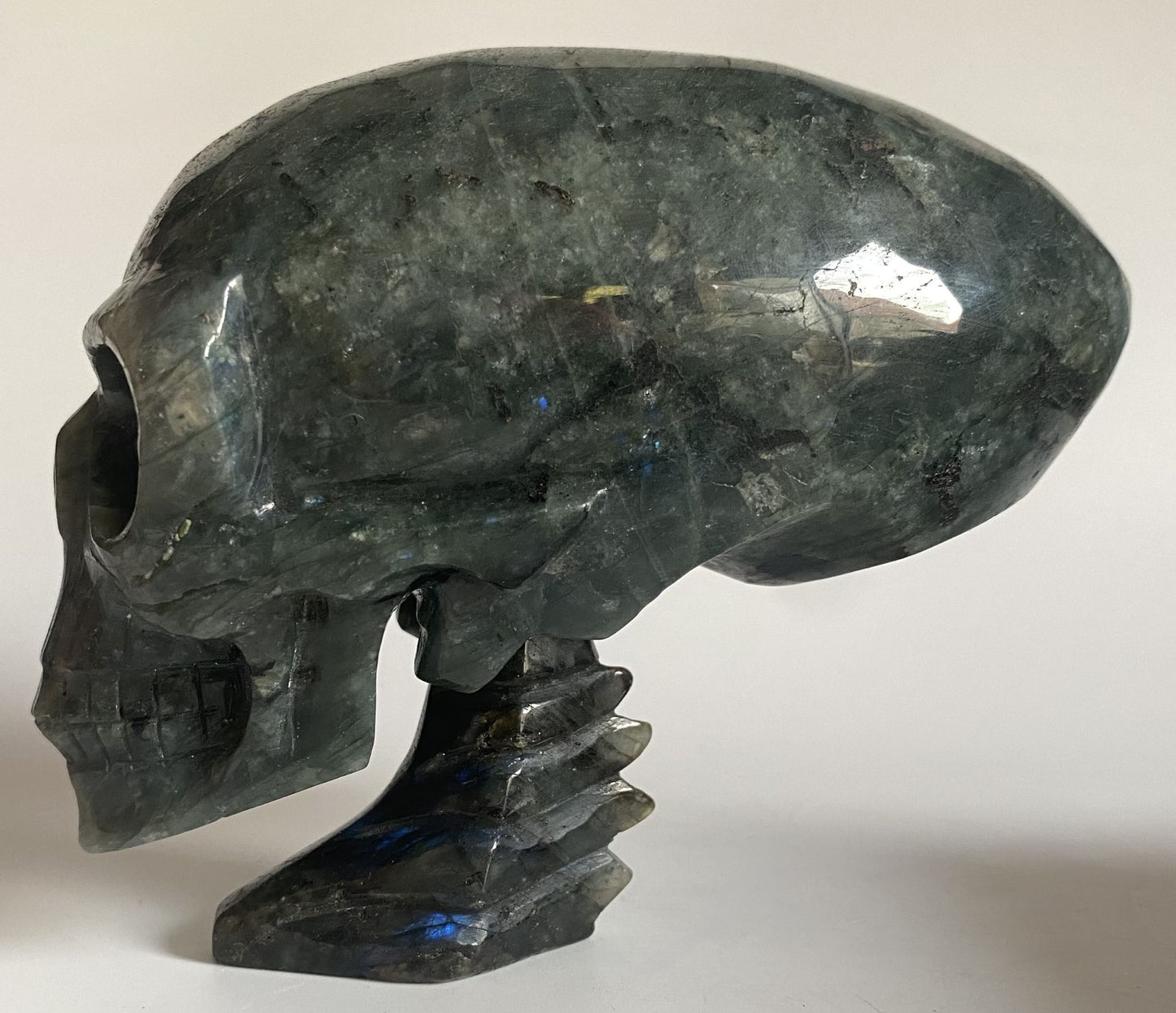 Craniu sculptat din piatra semipretioasa de labradorit pe fundal alb