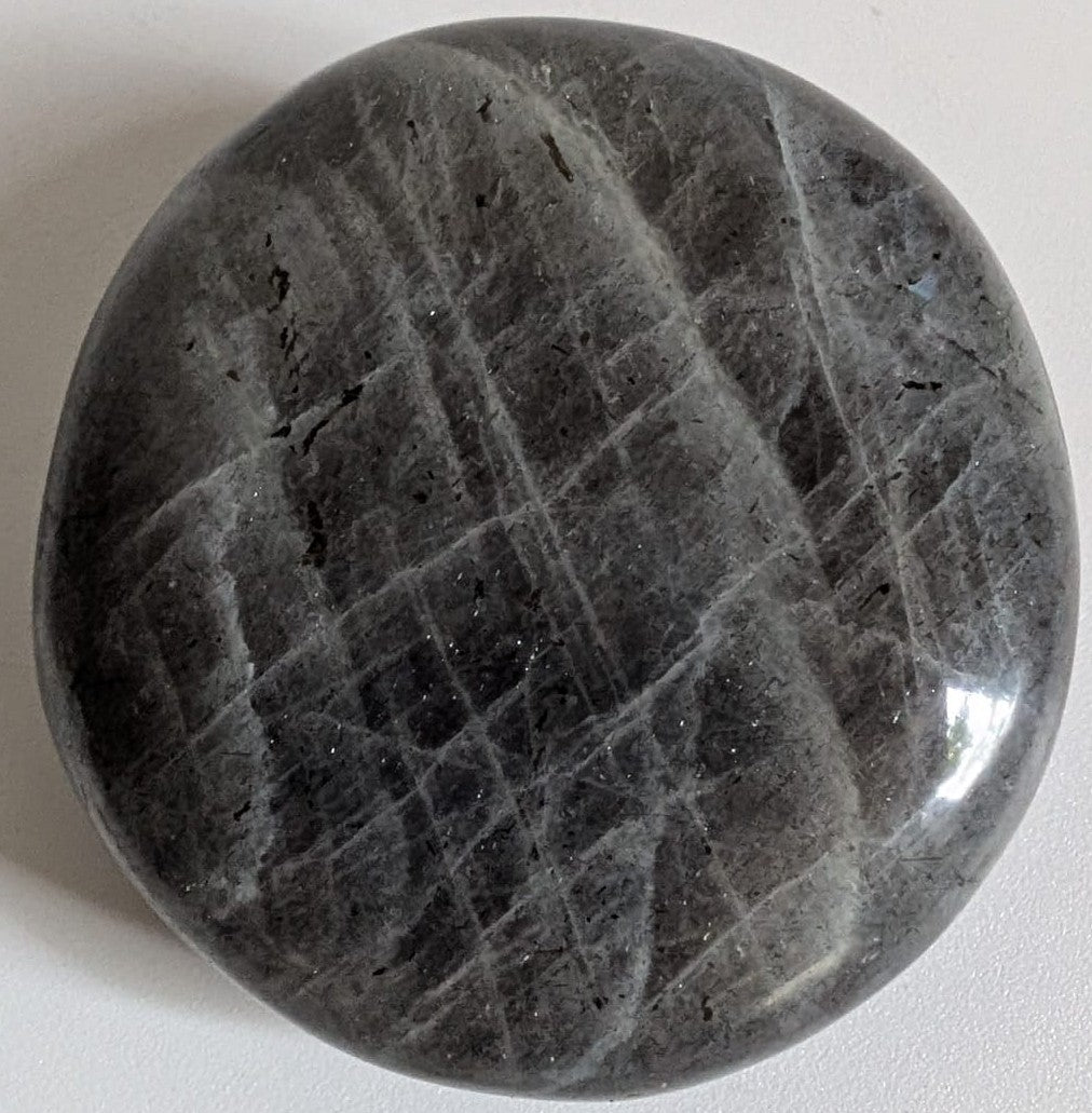 Palm Stone din cristal de labradorit mov pe fundal alb