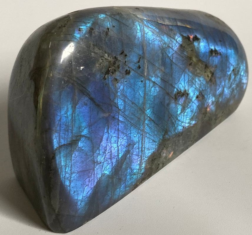 Sculptura din cristal de labradorit mov pe fundal alb