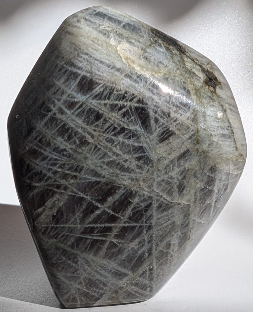 Sculptura din cristal de labradorit mov pe fundal alb