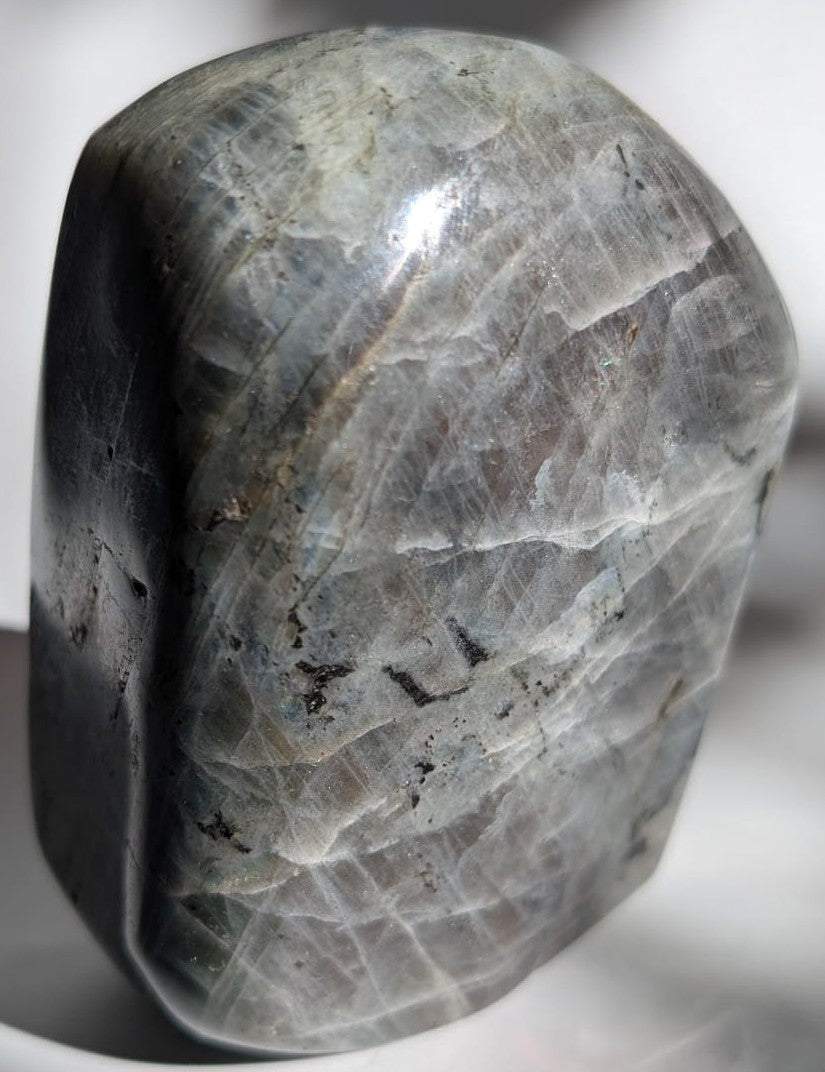 Sculptura din cristal de labradorit mov pe fundal alb