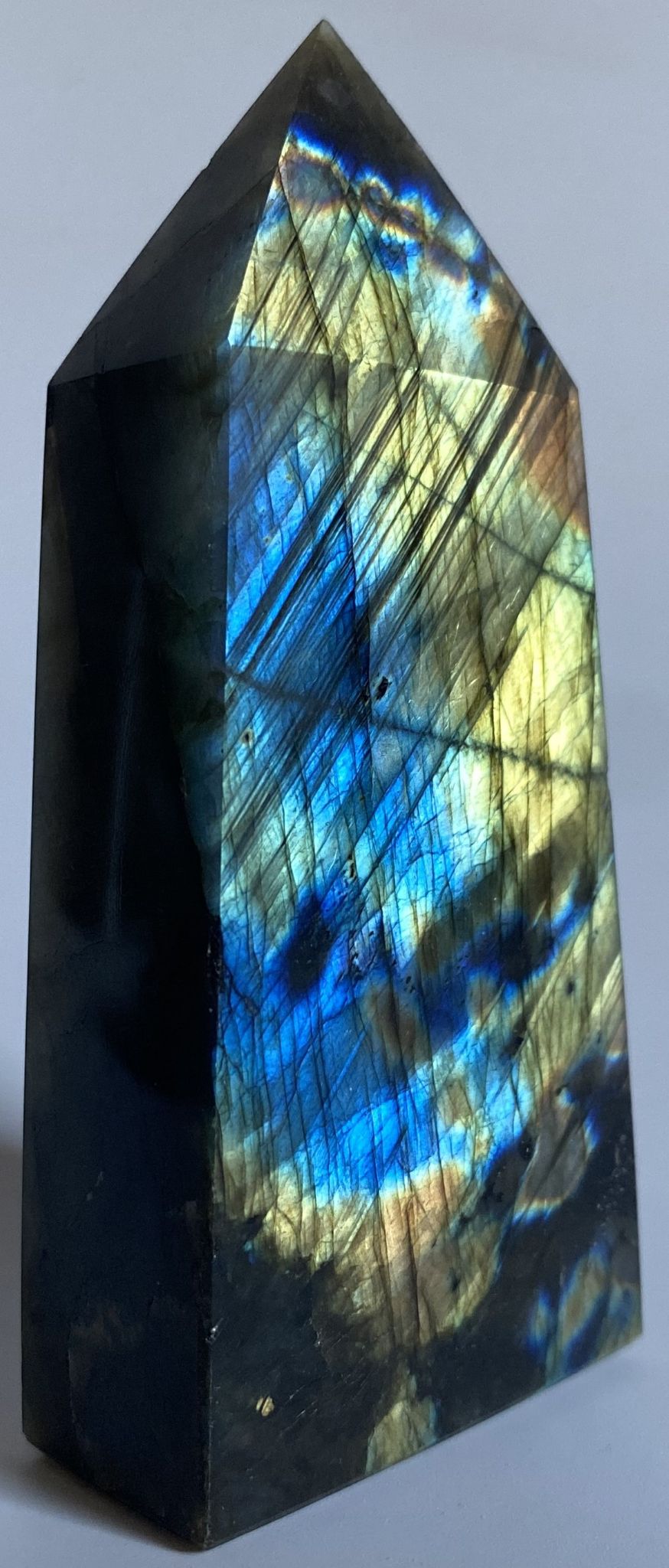 Obelisc din cristal de labradorit pe fundal alb