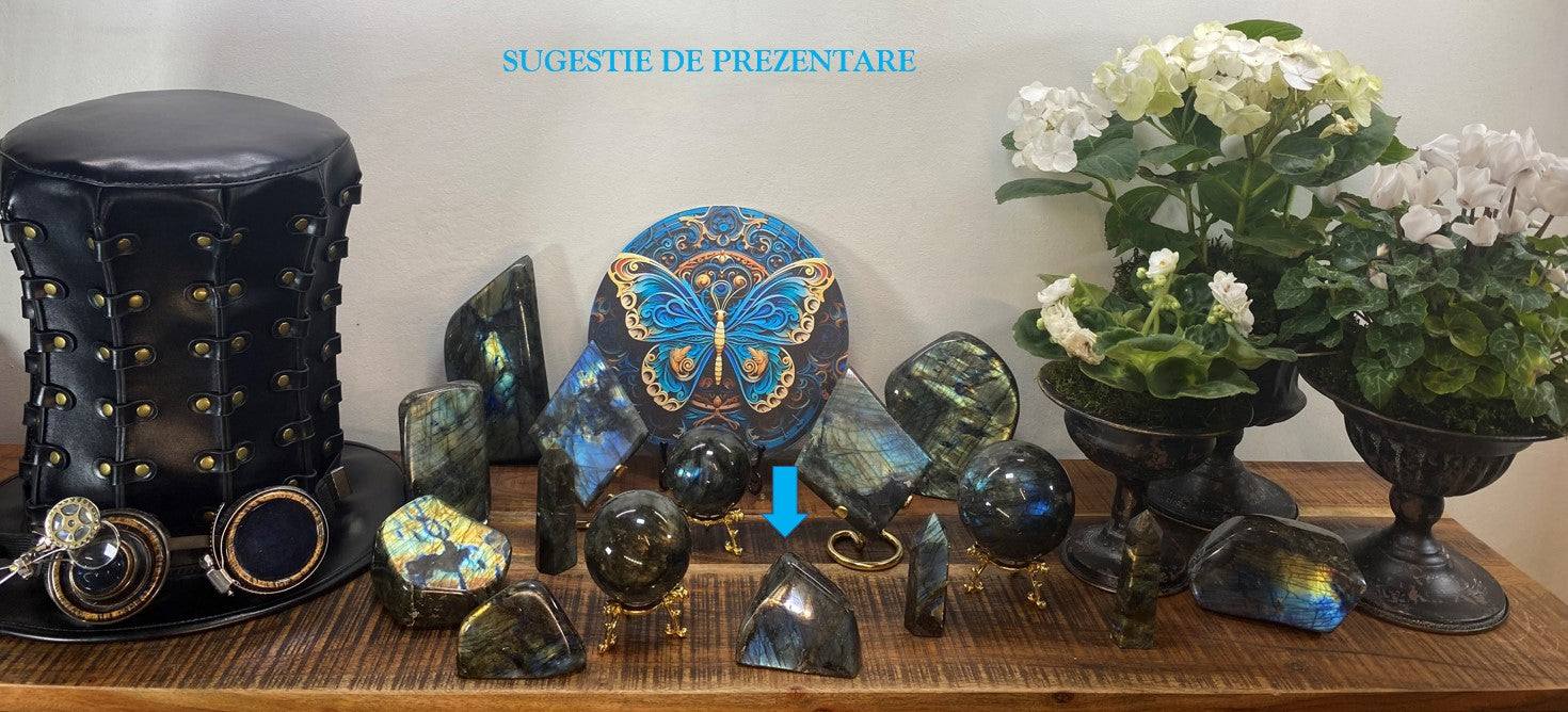 Labradorit sculptura piatra semipretioasa cu irizatii albastre-galbene pe suport lemn langa flori si accesoriu negru vintage