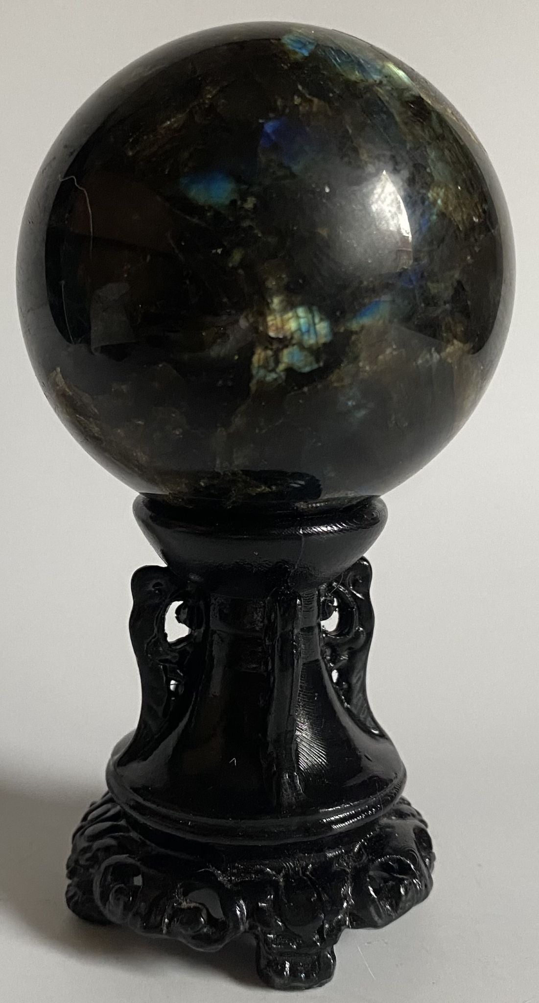 Sfera din cristal de labradorit pe suport decorativ cu fundal alb