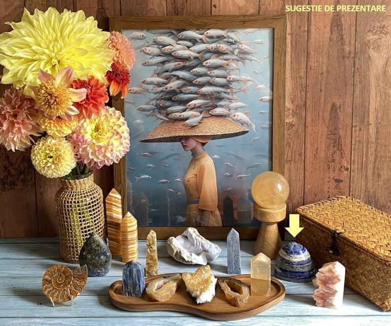 Lapis Lazuli semiprecious stone sculpture displayed with various crystals and flowers on a wooden surface