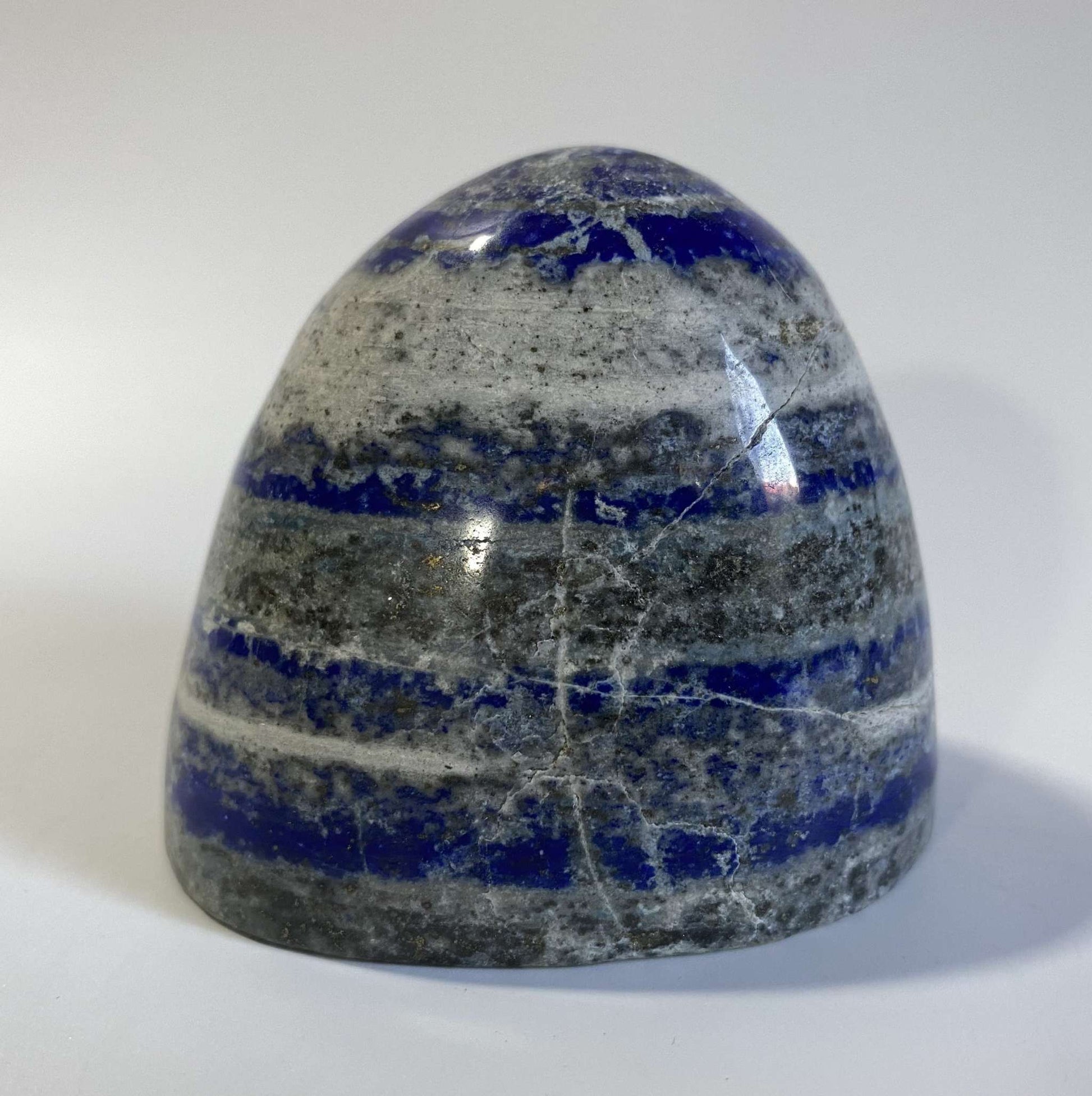 Polished Lapis Lazuli semi-precious stone sculpture with blue and gray layers