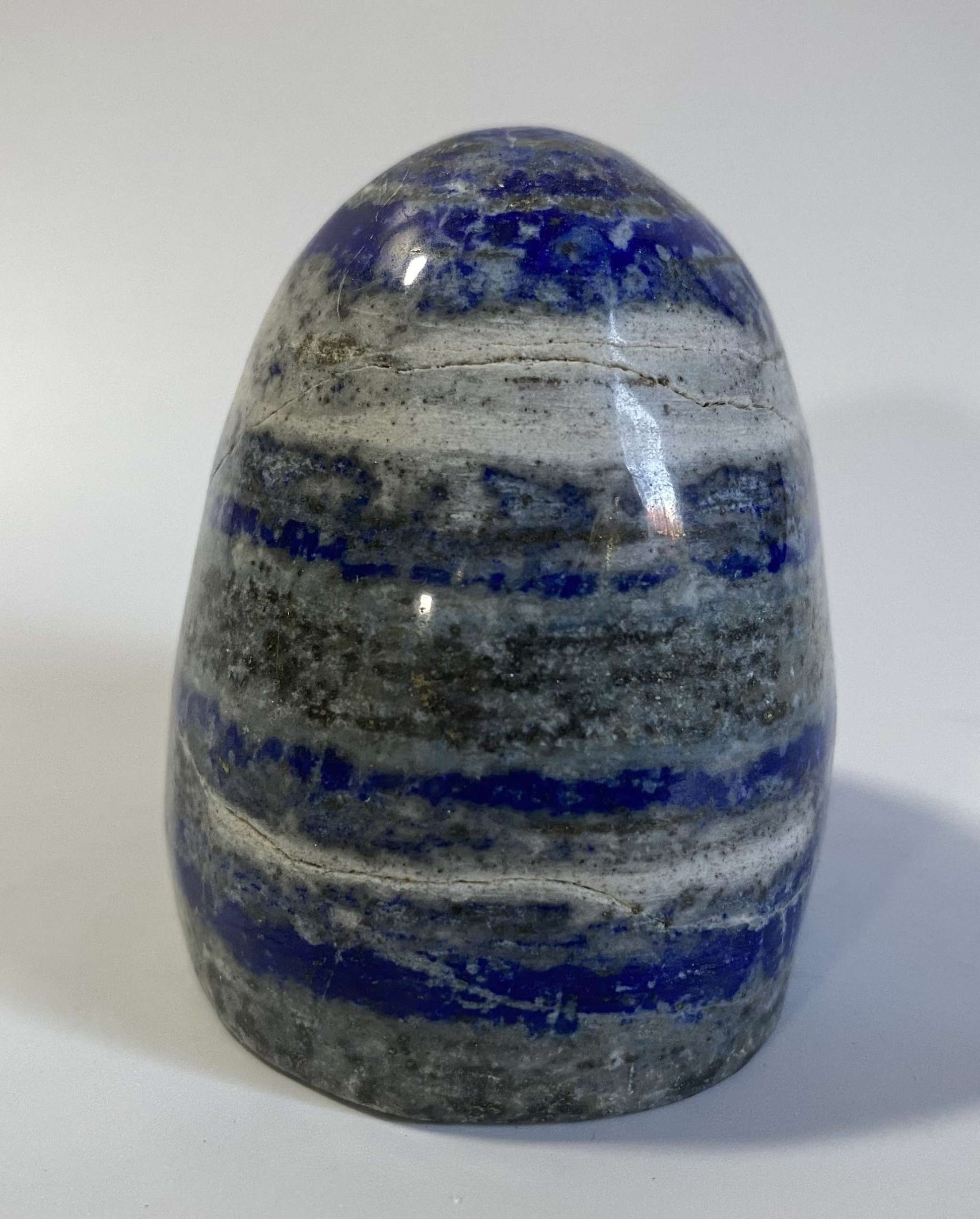 Polished Lapis Lazuli semi-precious stone sculpture with blue and white layers