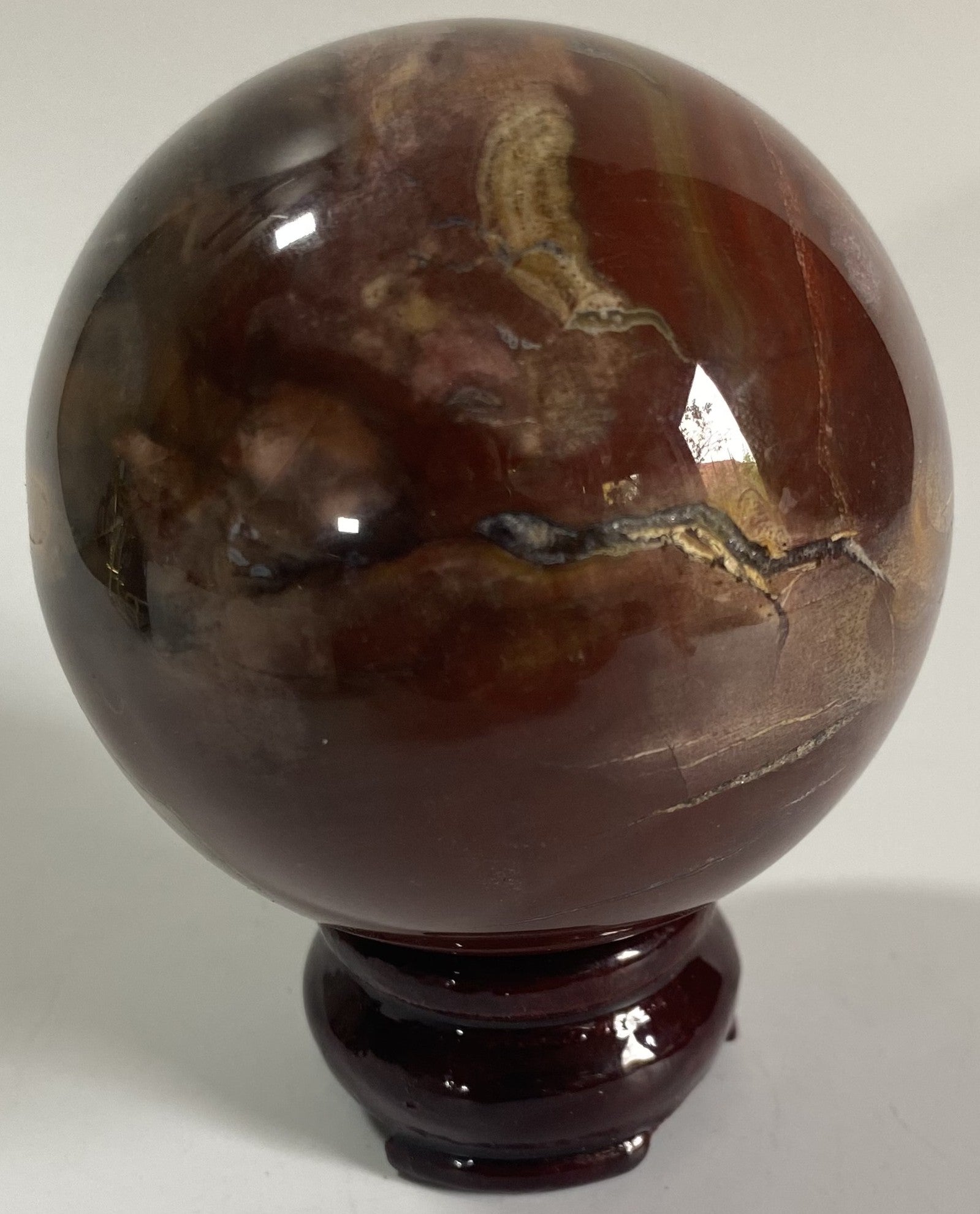 Sfera decorativa de 7cm din piatra semipretioasa de lemn fosilizat pe suport din lemn cu fundal alb