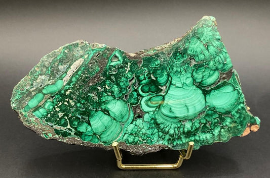 Felie din piatra semipretioasa de malachit pe suport metalic cu fundal negru