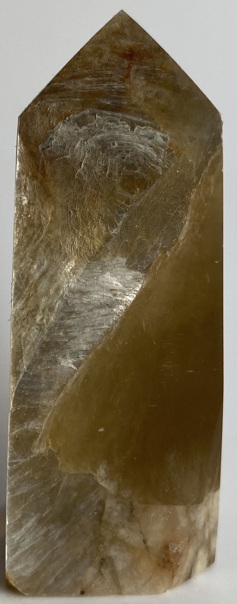 Obelisc din cristal de mica aurie pe fundal alb