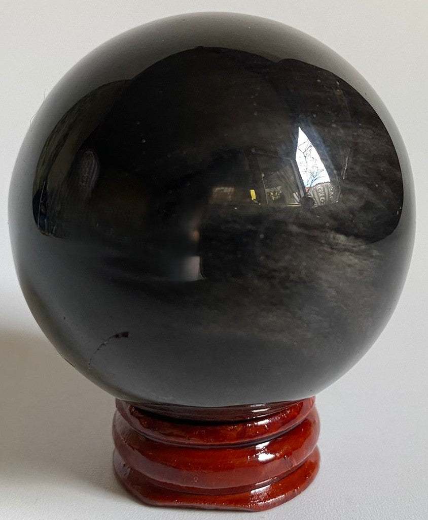 Sfera decorativa de 5.4cm din cristal de obsidian argintiu pe suport din lemn cu fundal negru