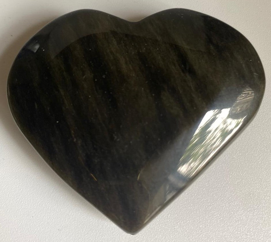 Inima din piatra semipretioasa de obsidian auriu pe fundal alb