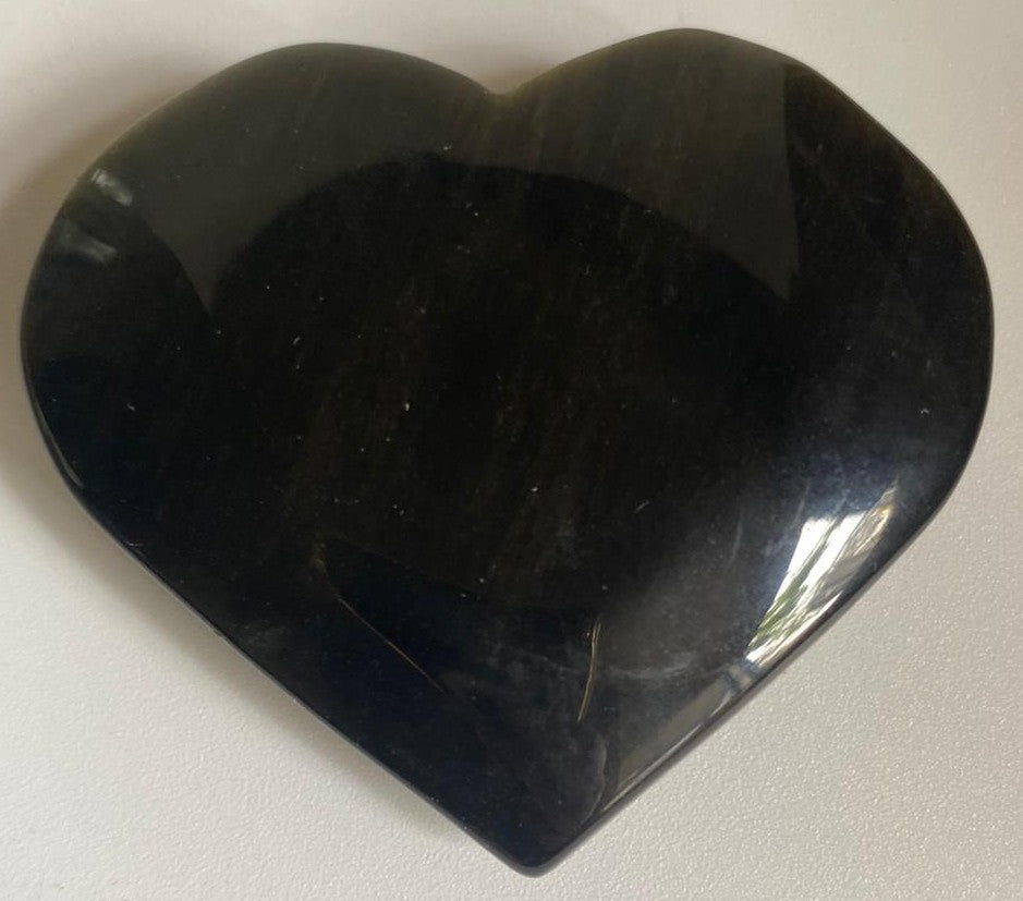 Inima din cristal de obsidian auriu pe fundal alb
