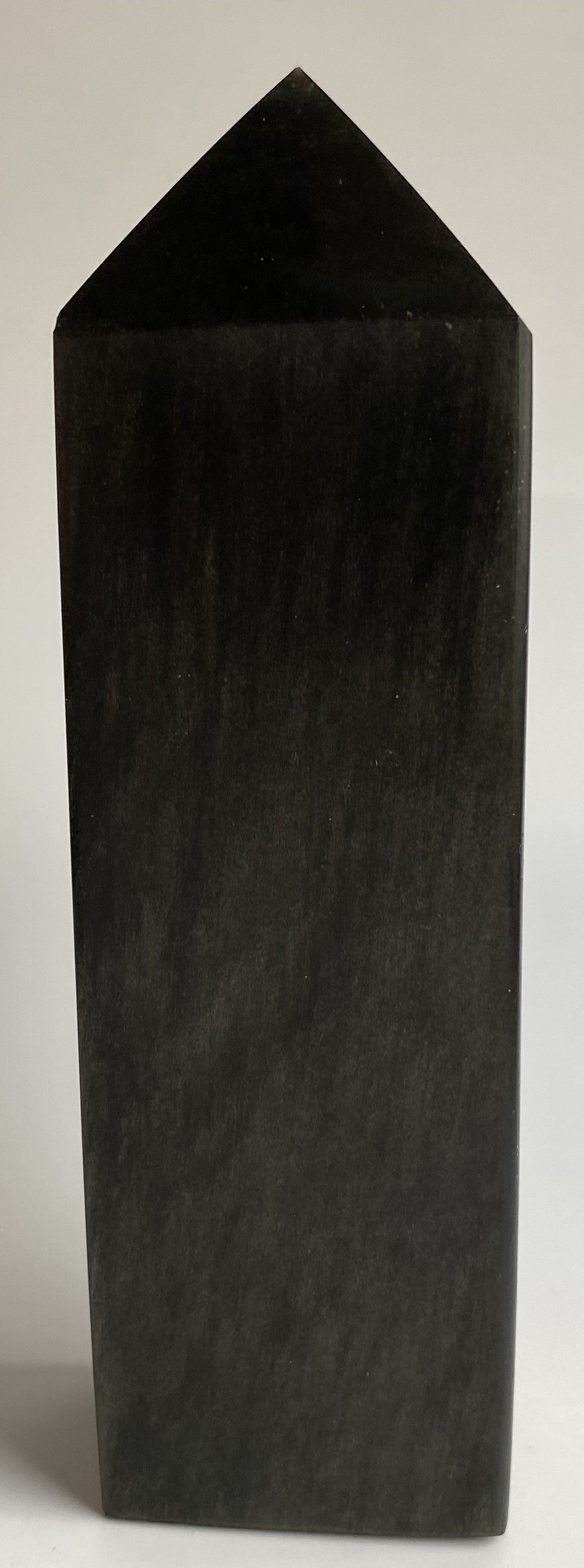 Obelisc din mineral de obsidian auriu pe fond alb si in lumina naturala