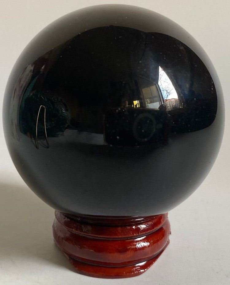 Sfera din cristal de obsidian curcubeu pe suport din lemn cu fundal alb