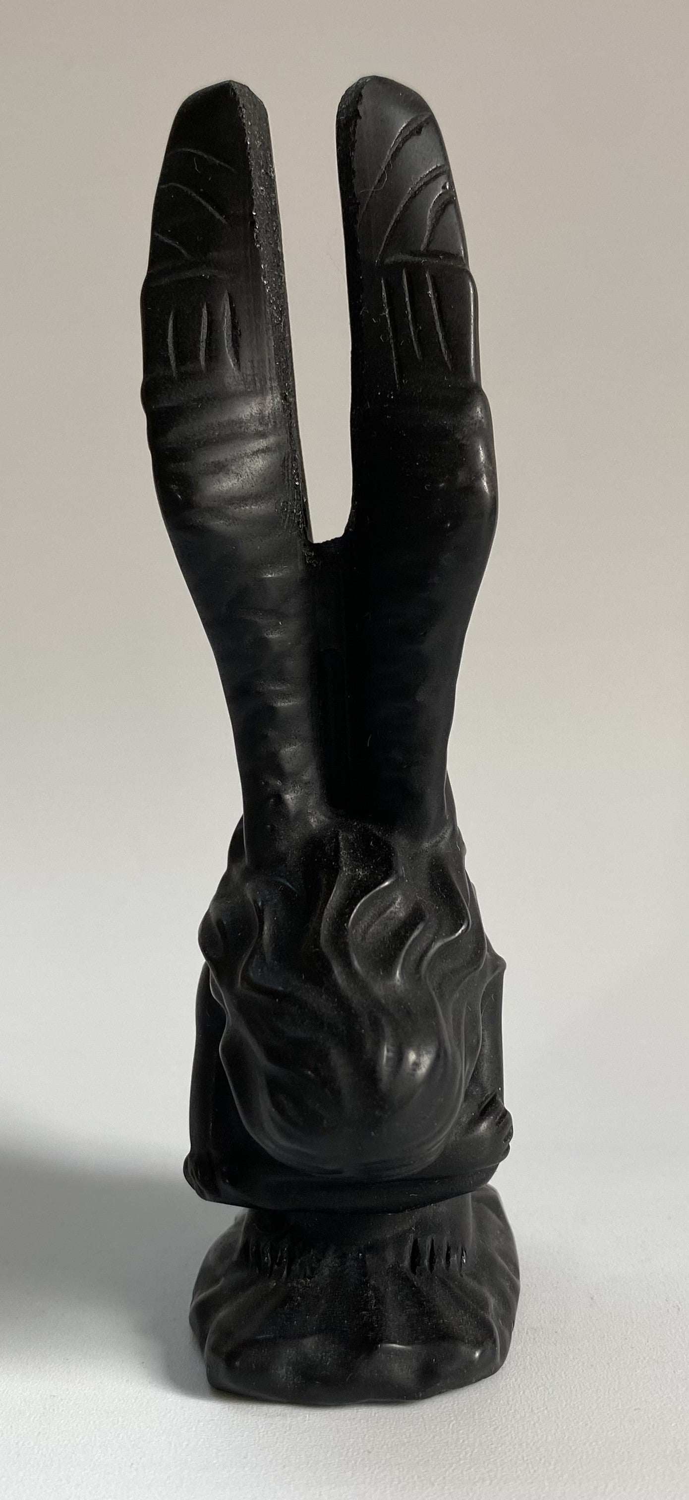 Sculpture of an Obsidian angel figurine with detailed wings and base.