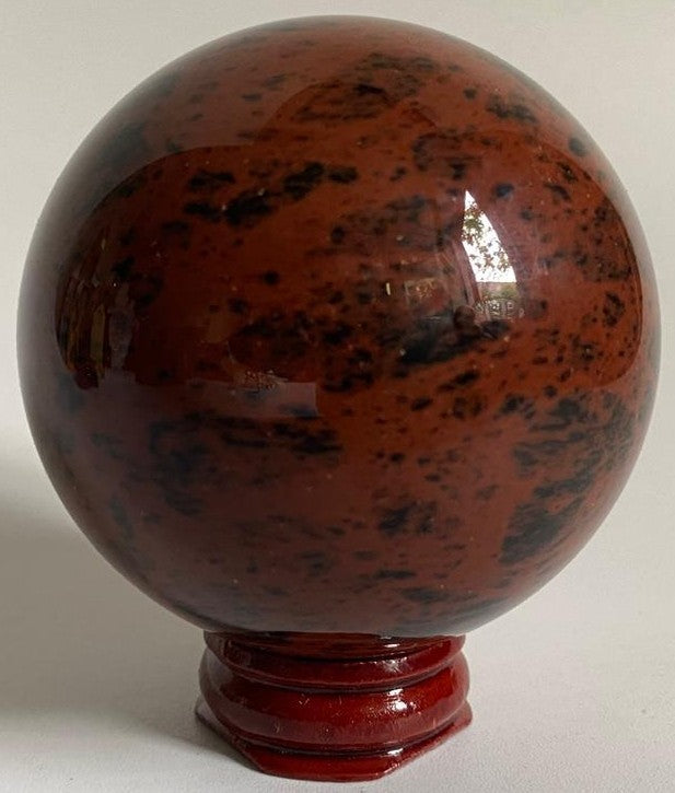 Sfera din cristal de obsidian mahon pe suport din lemn cu fundal alb