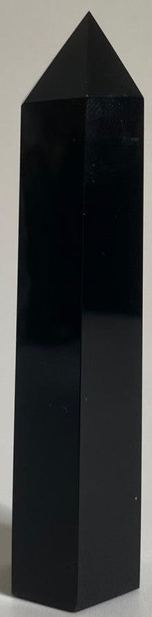 Obelisc din cristal de obsidian pe fundal alb
