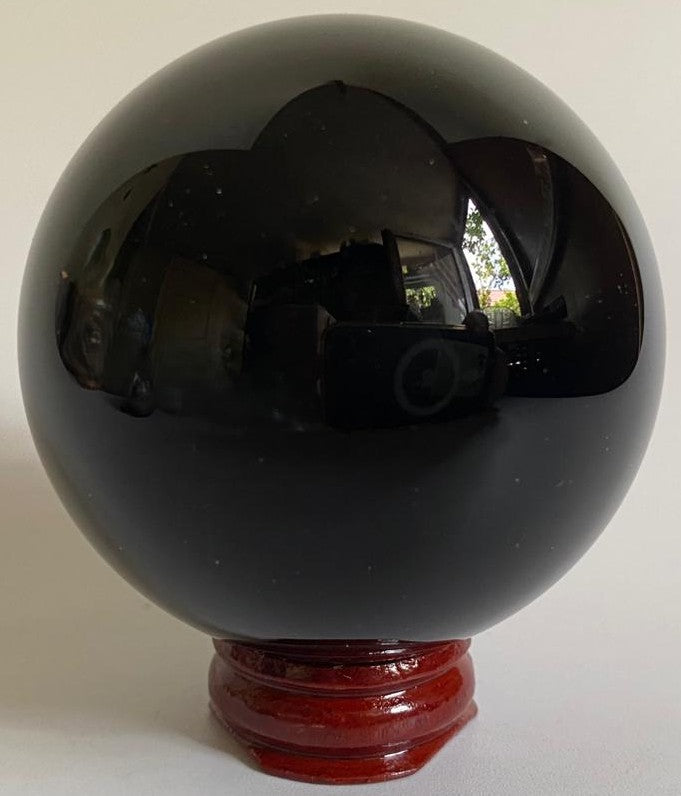 Sfera din piatra semipretioasa de obsidian negru pe fundal alb