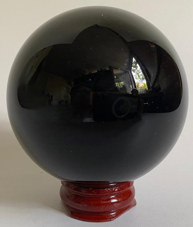 Sfera din cristal de obsidian negru pe fundal alb