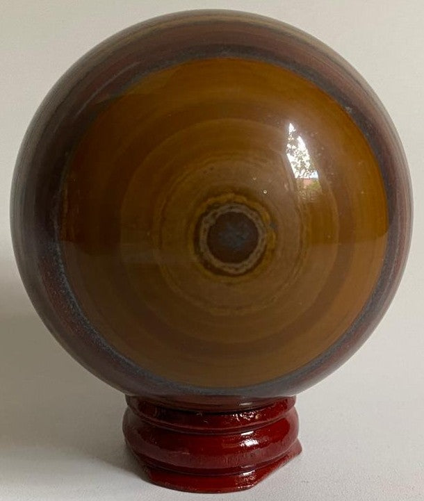 Sfera de 6.3cm din piatra semipretioasa de ochi de tigru cu fier pe suport din lemn cu fundal alb
