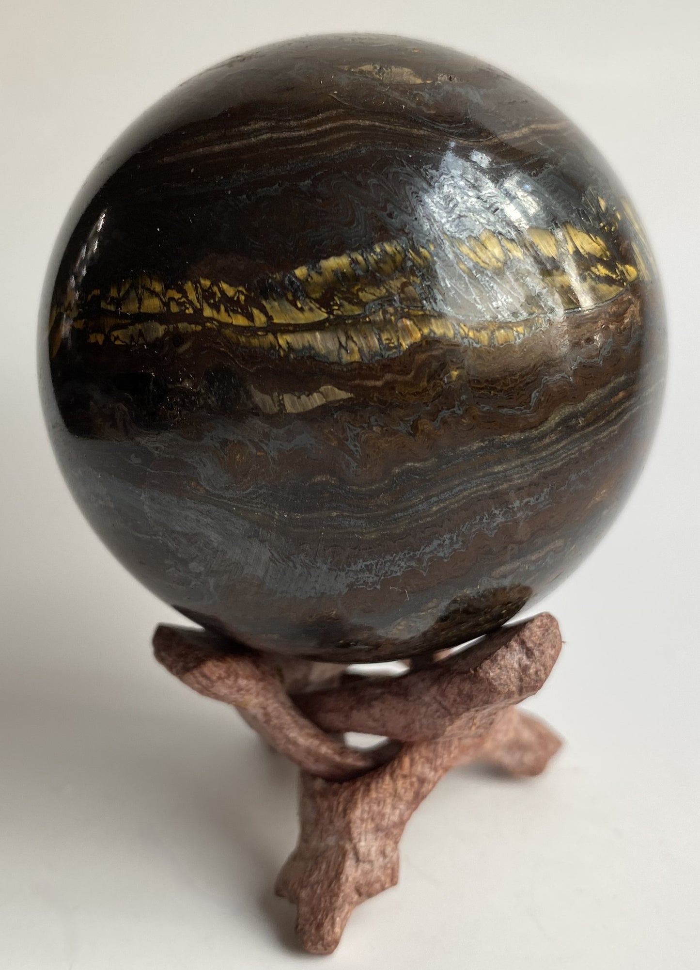 Sfera din ochi de tigru cu fier pe fond alb sub lumina naturala