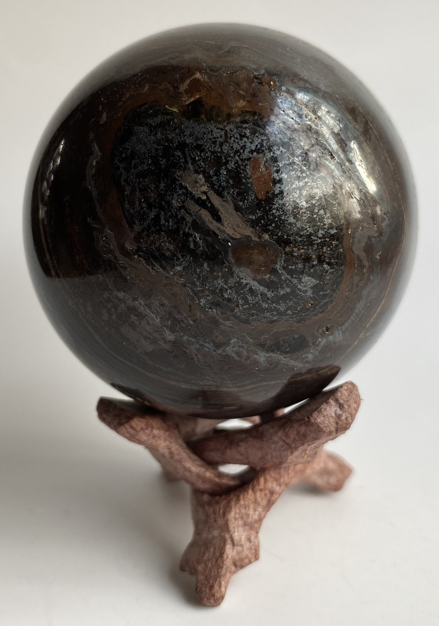 Sfera din ochi de tigru cu fier pe fond alb sub lumina naturala