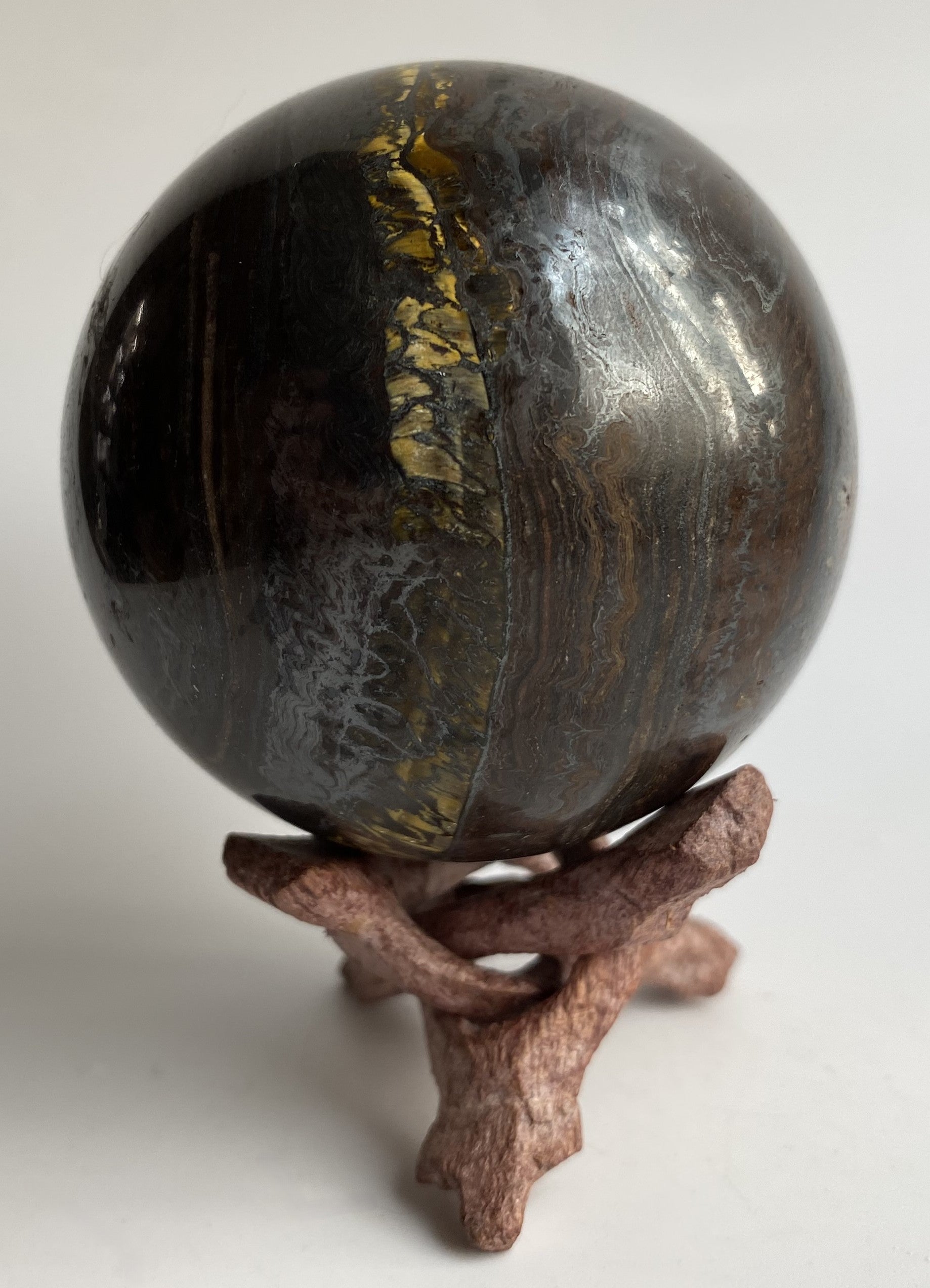 Sfera din ochi de tigru cu fier pe fond alb sub lumina naturala