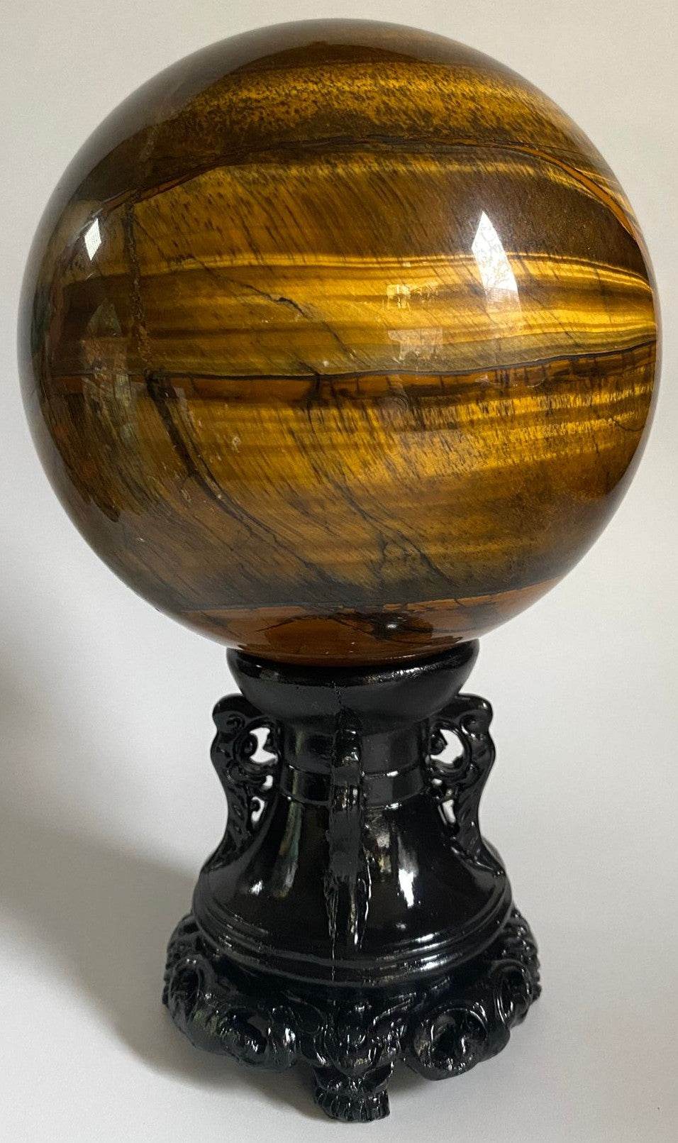 Sfera din piatra semipretioasa de ochi de tigru pe suport decorativ cu fundal alb