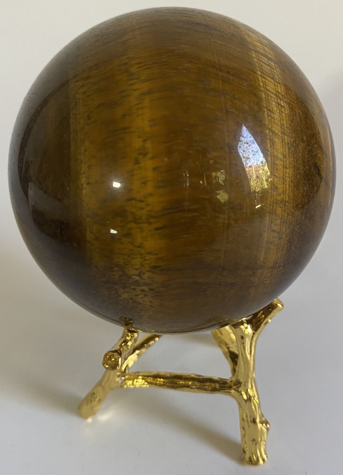 Sfera de 6.8cm din piatra semipretioasa de ochi de tigru su suport metalic pe fundal alb