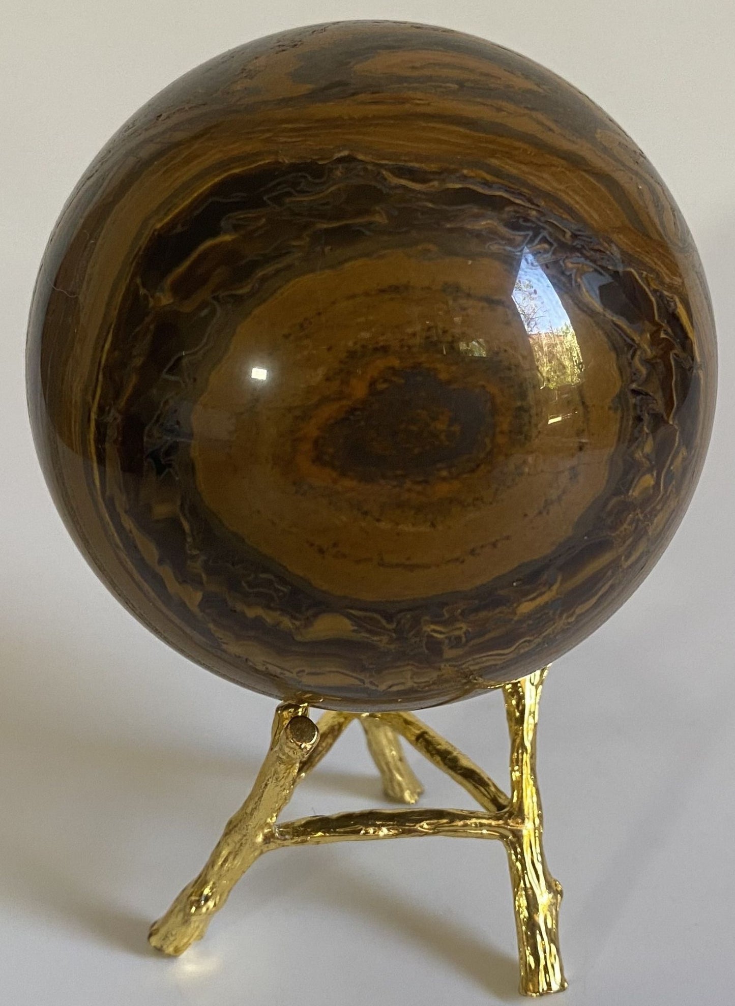 Sfera din cristal de ochi de tigru cu fier pe suport metalic cu fundal alb