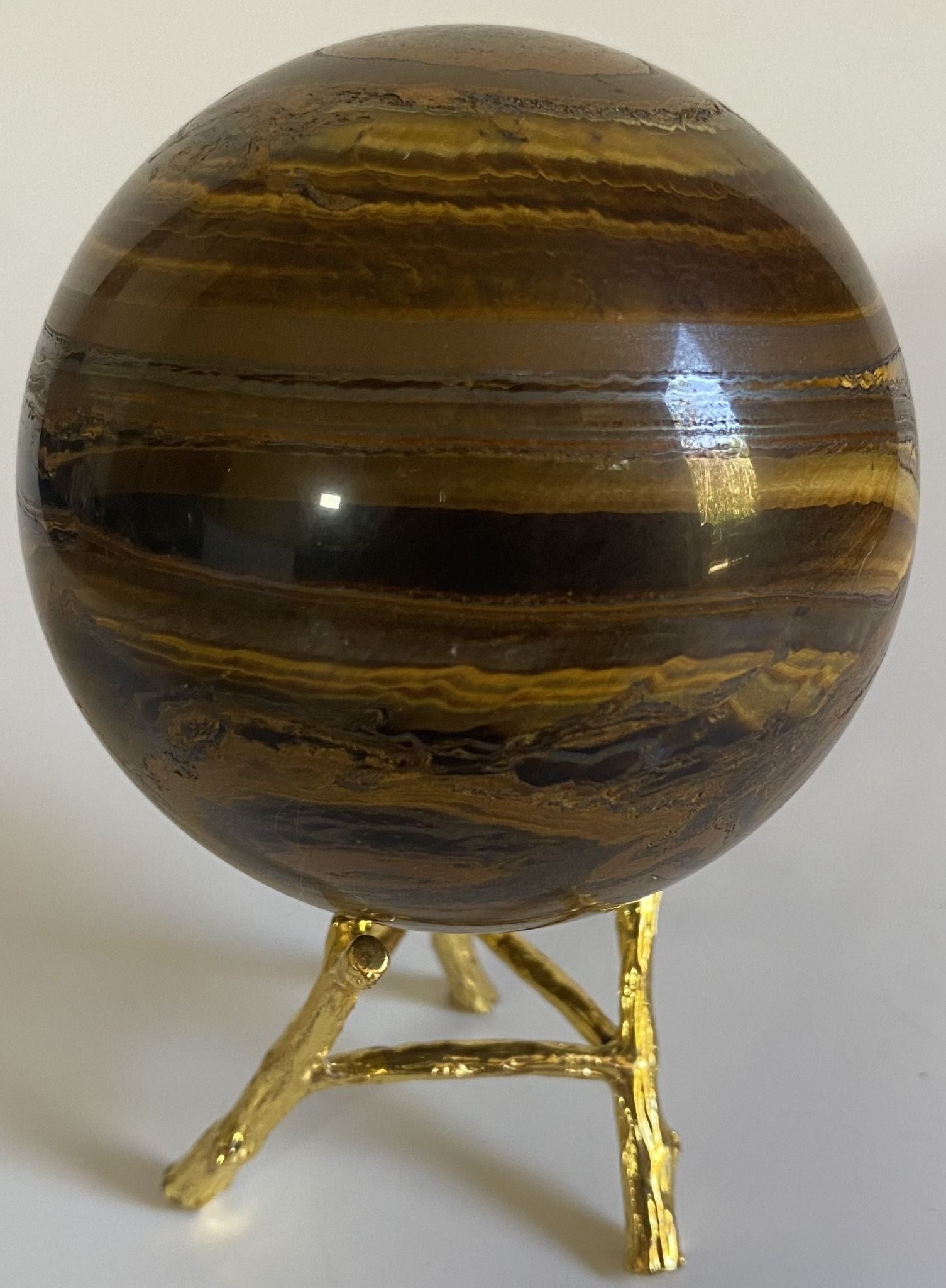 Sfera de 7.9cm din piatra semipretioasa de ochi de tigru cu fier pe suport metalic cu fundal alb