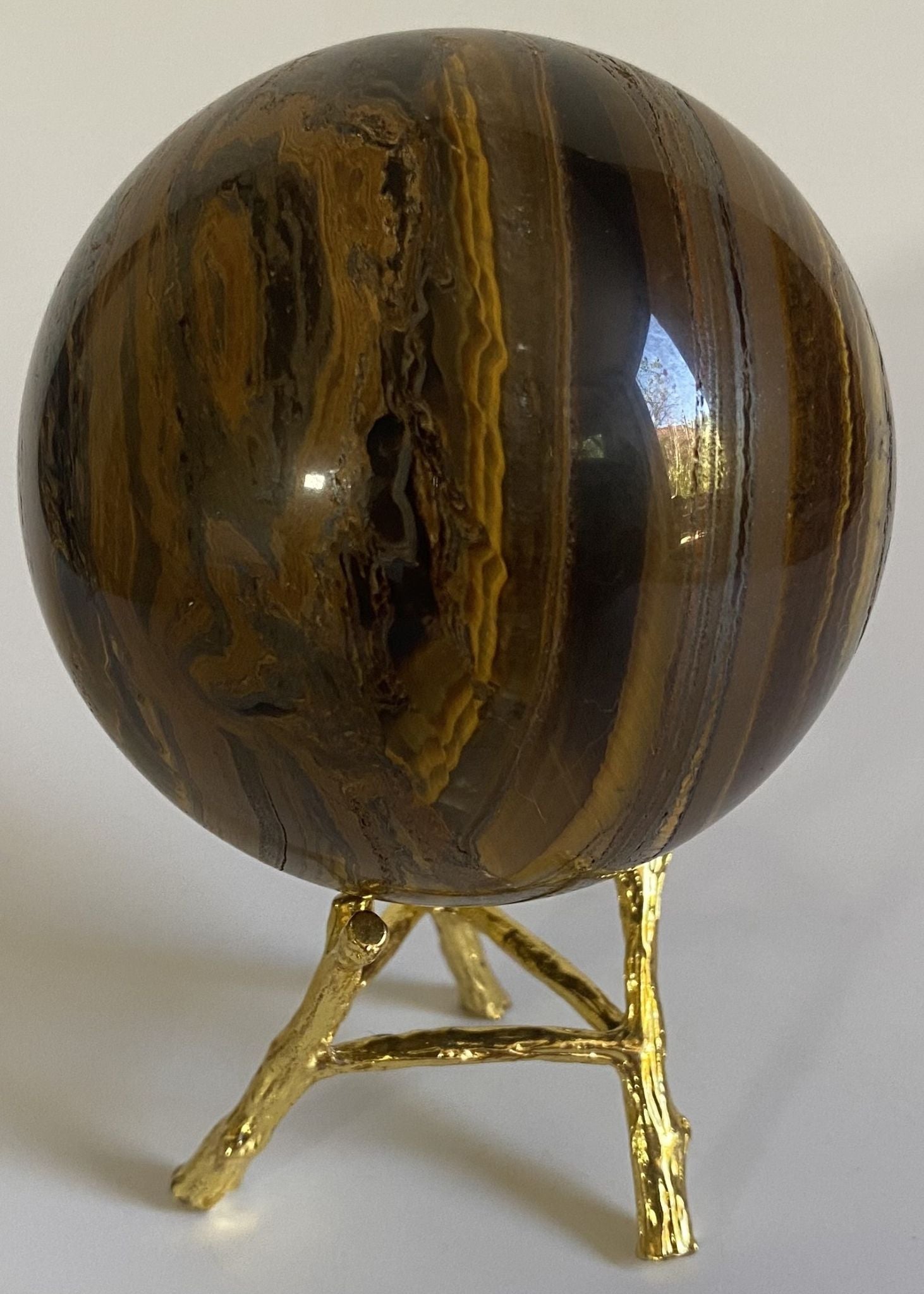 Sfera de 7.9cm din cristal de ochi de tigru cu fier pe suport metalic cu fundal alb