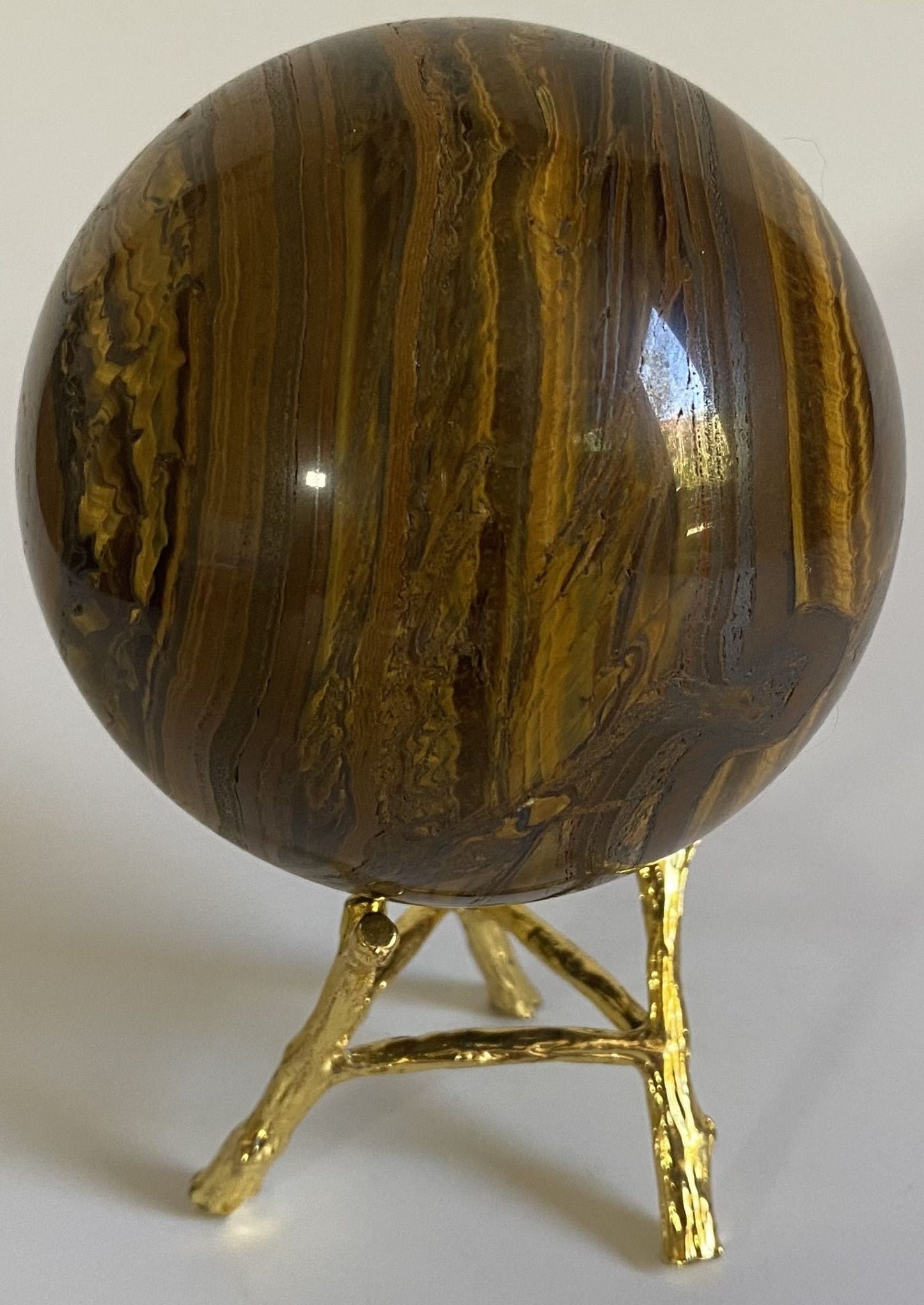 Sfera decorativa de 7.9cm din piatra semipretioasa de ochi de tigru cu fier pe suport metalic cu fundal alb