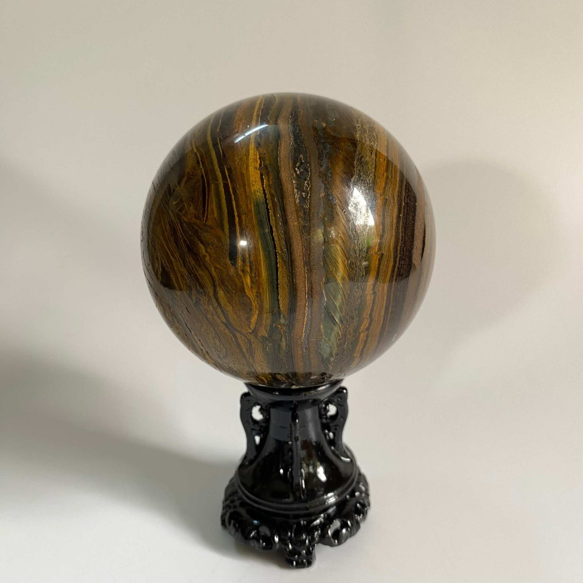 Ochi de Tigru cu Fier semiprecious stone sphere on black stand