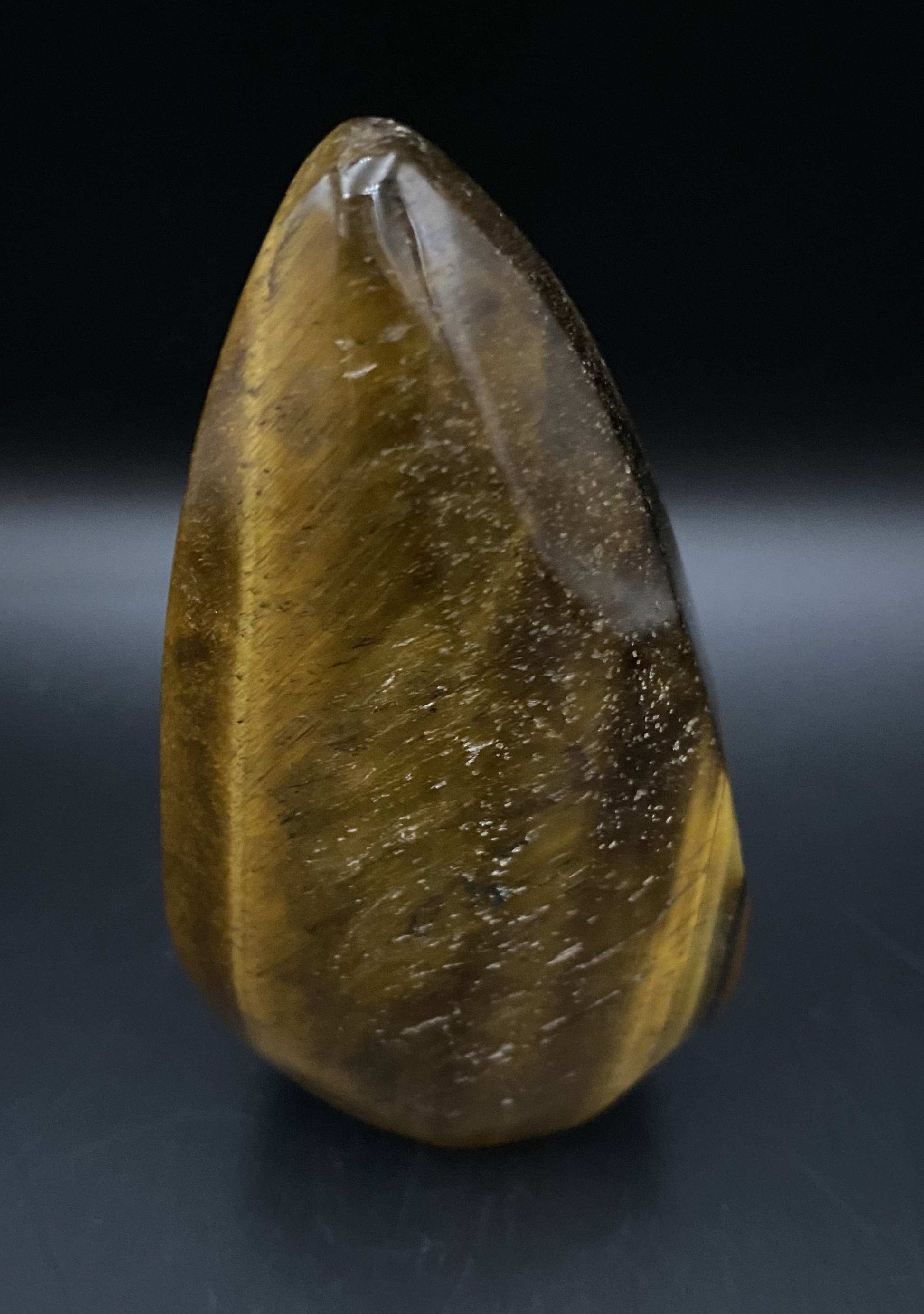 Ochi de Tigru polished semiprecious stone sculpture on black background