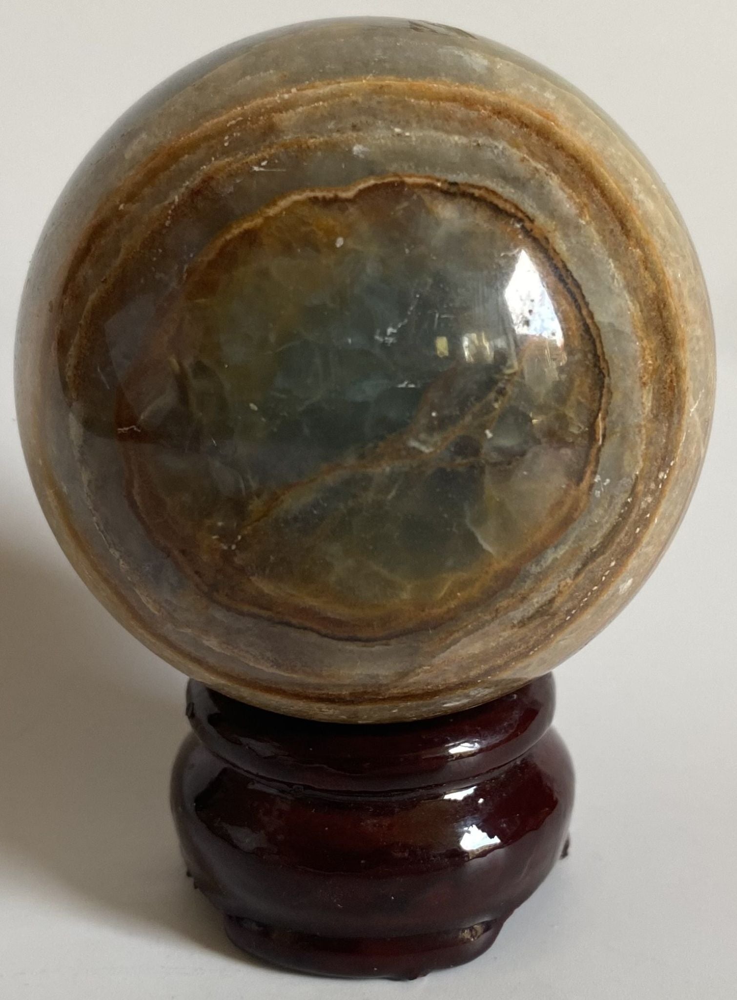 Sfera de 6.4cm din cristal de onix albastru pe suport din lemn cu fundal alb